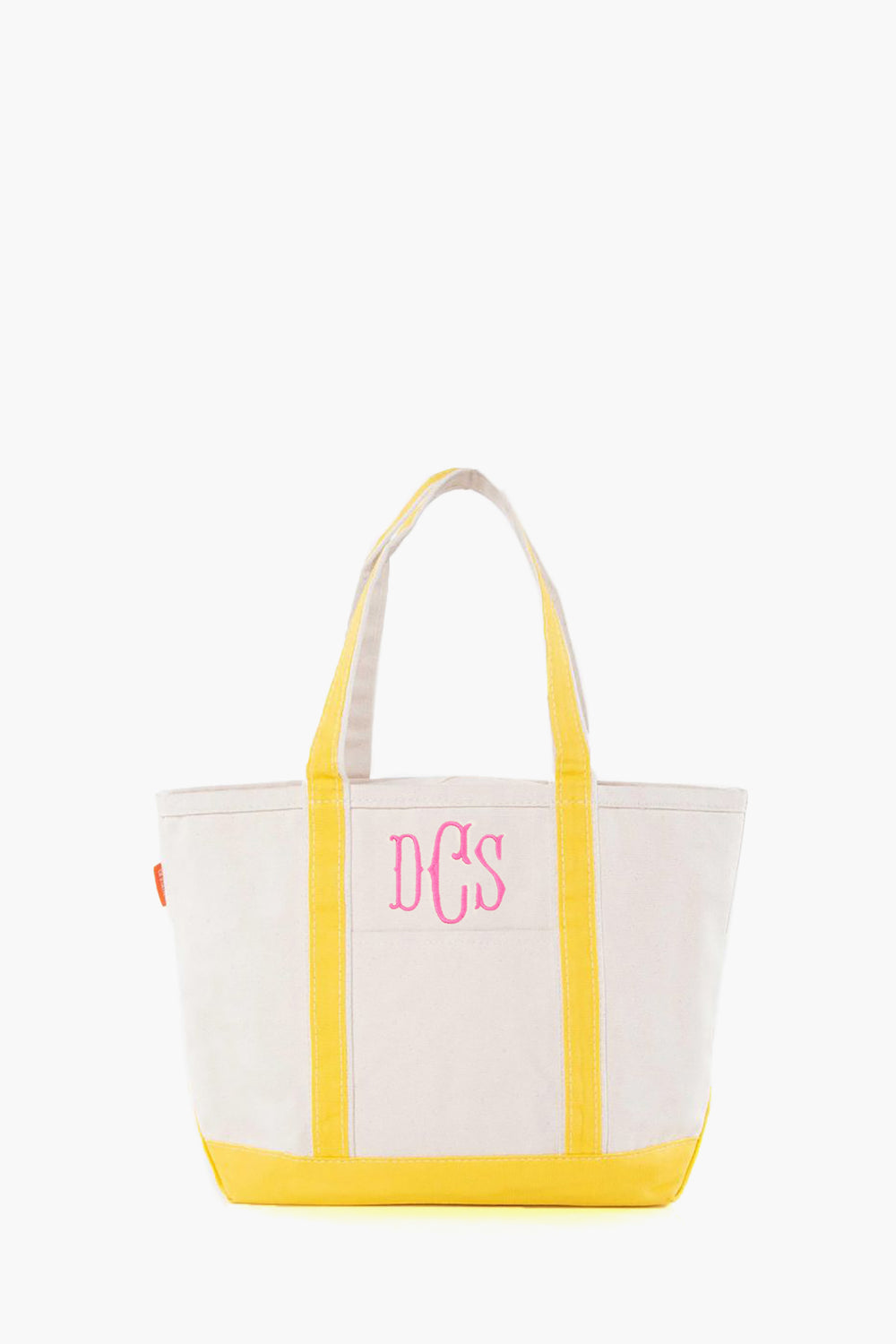 The CB Station beige canvas tote bag features yellow handles and trim, plus pink DCS monogram initials on the front. This stylish, reusable bag is ideal for everyday use.
