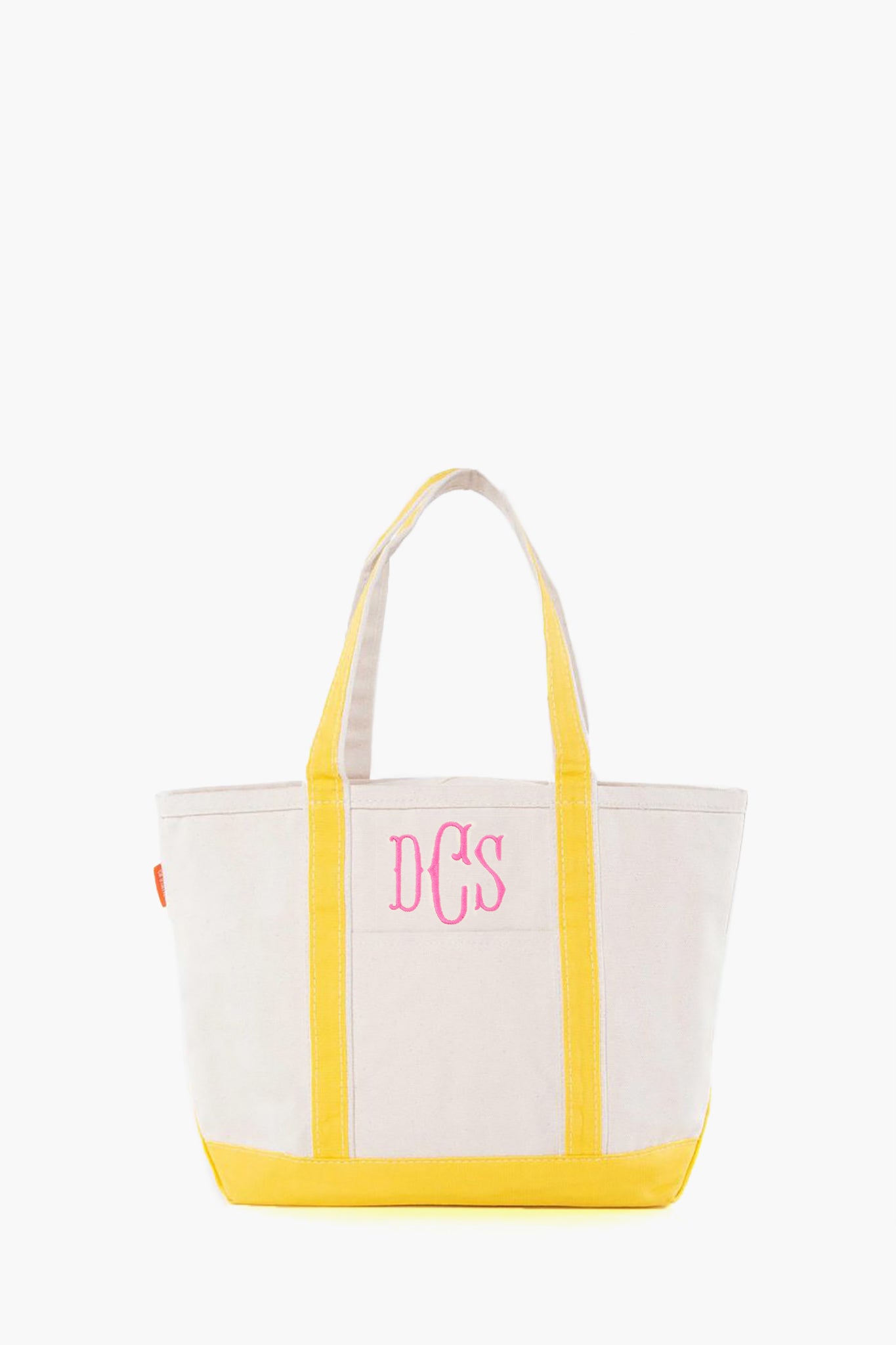 The CB Station beige canvas tote bag features yellow handles and trim, plus pink DCS monogram initials on the front. This stylish, reusable bag is ideal for everyday use.