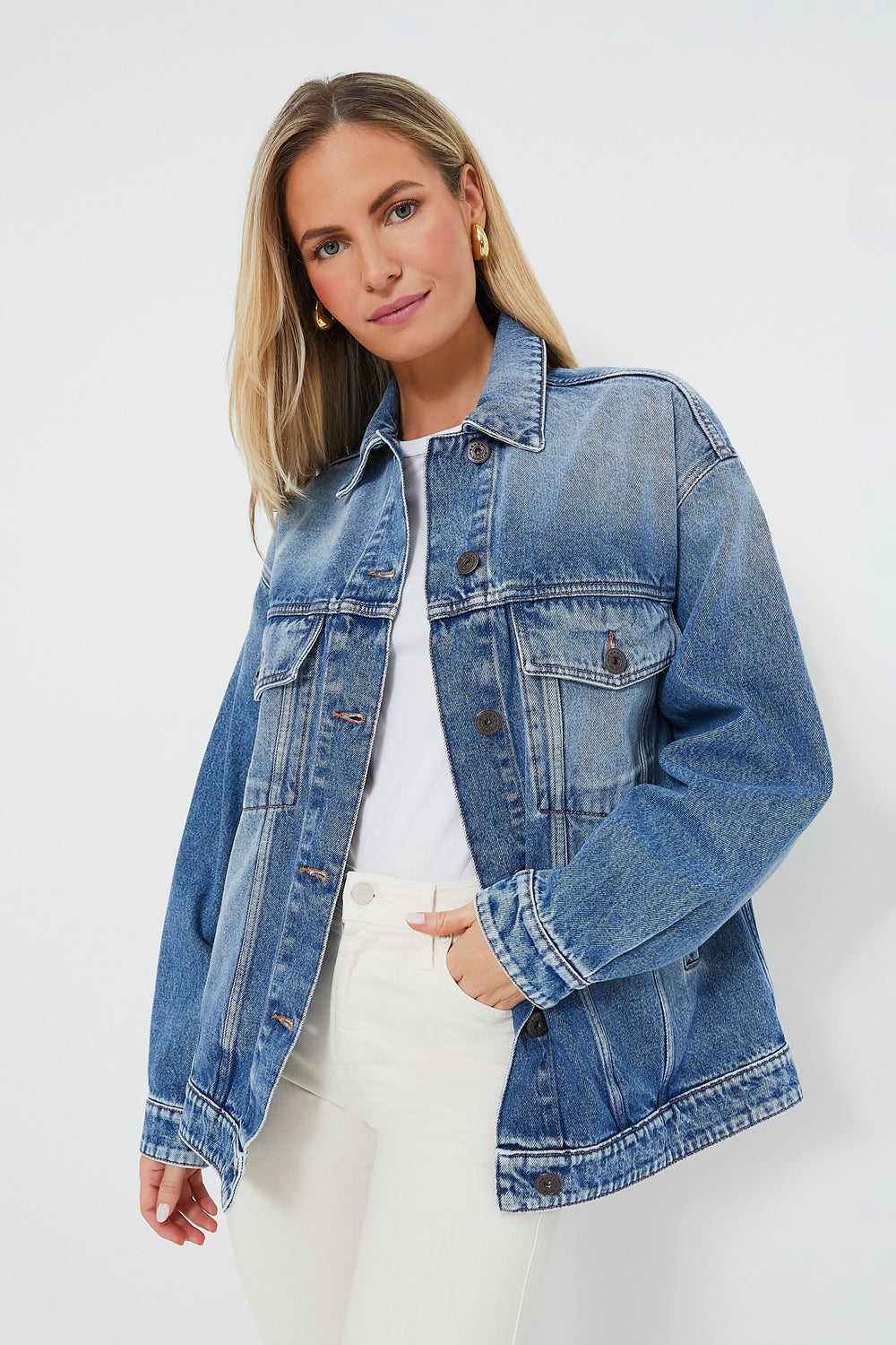 A woman wears a Weekend Max Mara denim jacket over a white shirt and pants, showcasing effortless style.
