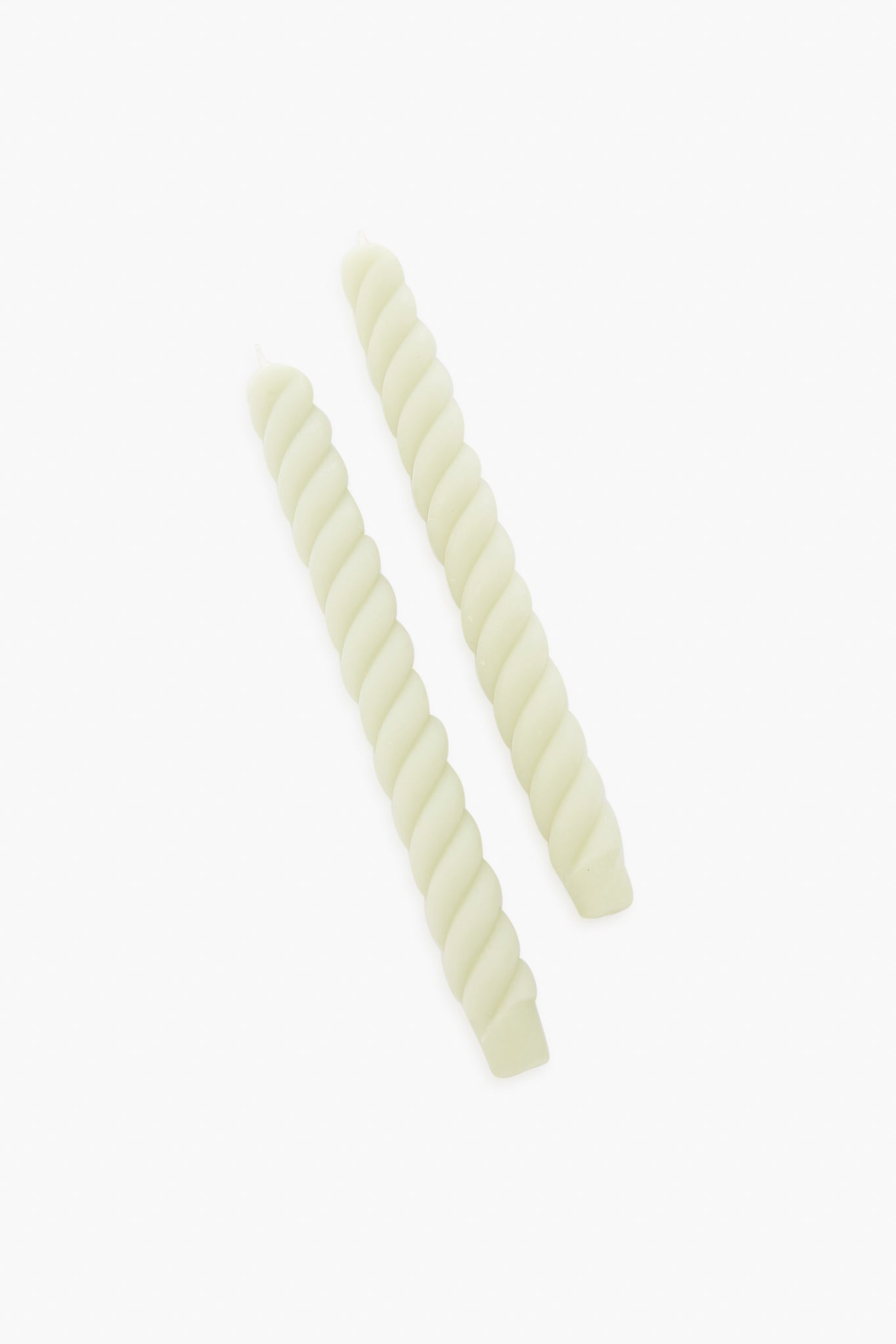 Two light-colored Greentree Home Rope Tapers, with their elegant twisted design, are displayed side by side. These beeswax candles make a charming housewarming gift.