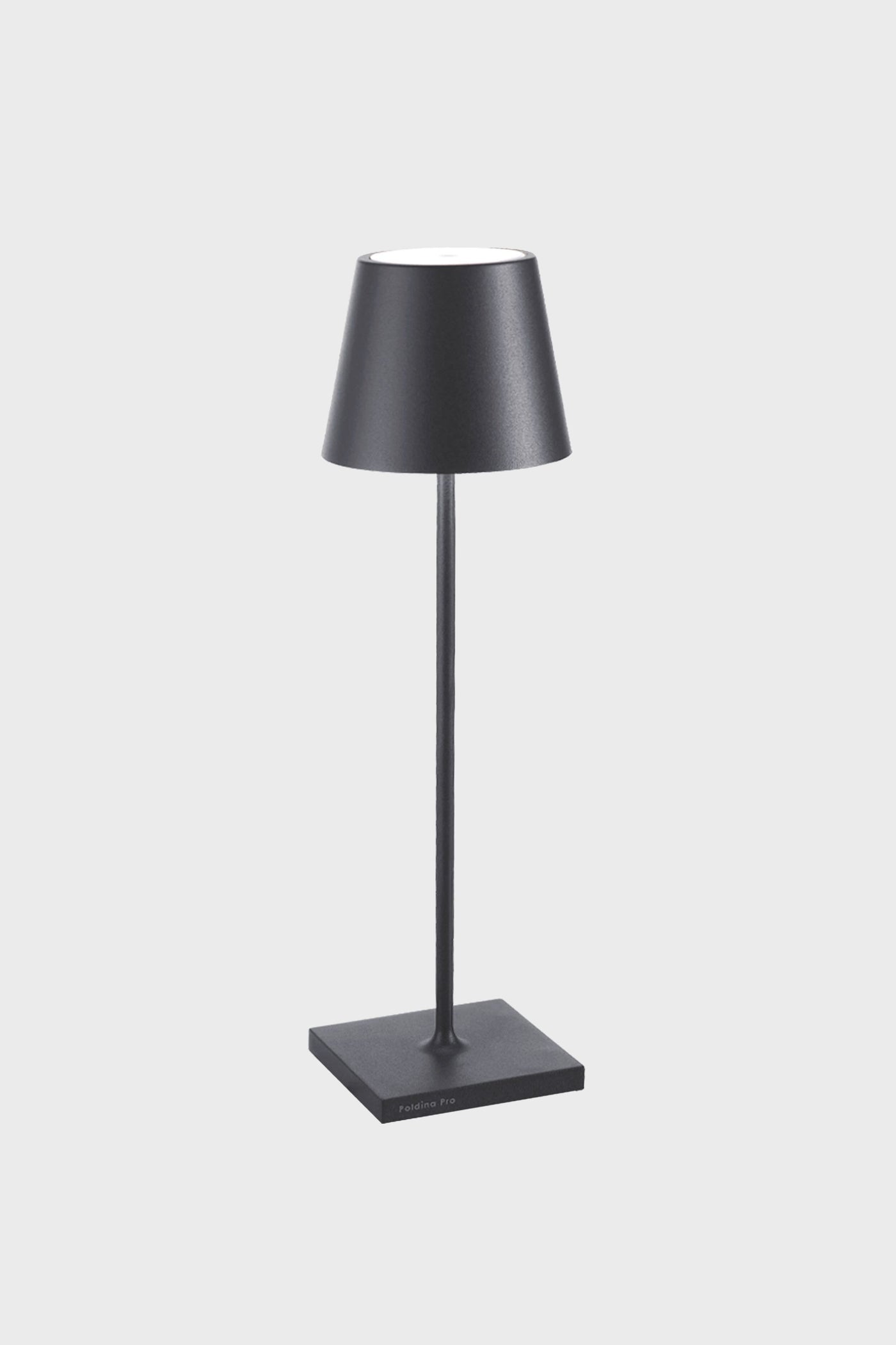 A black Zafferano Poldina Pro Table Lamp on a stand, featuring a rechargeable battery for cordless LED lighting convenience.