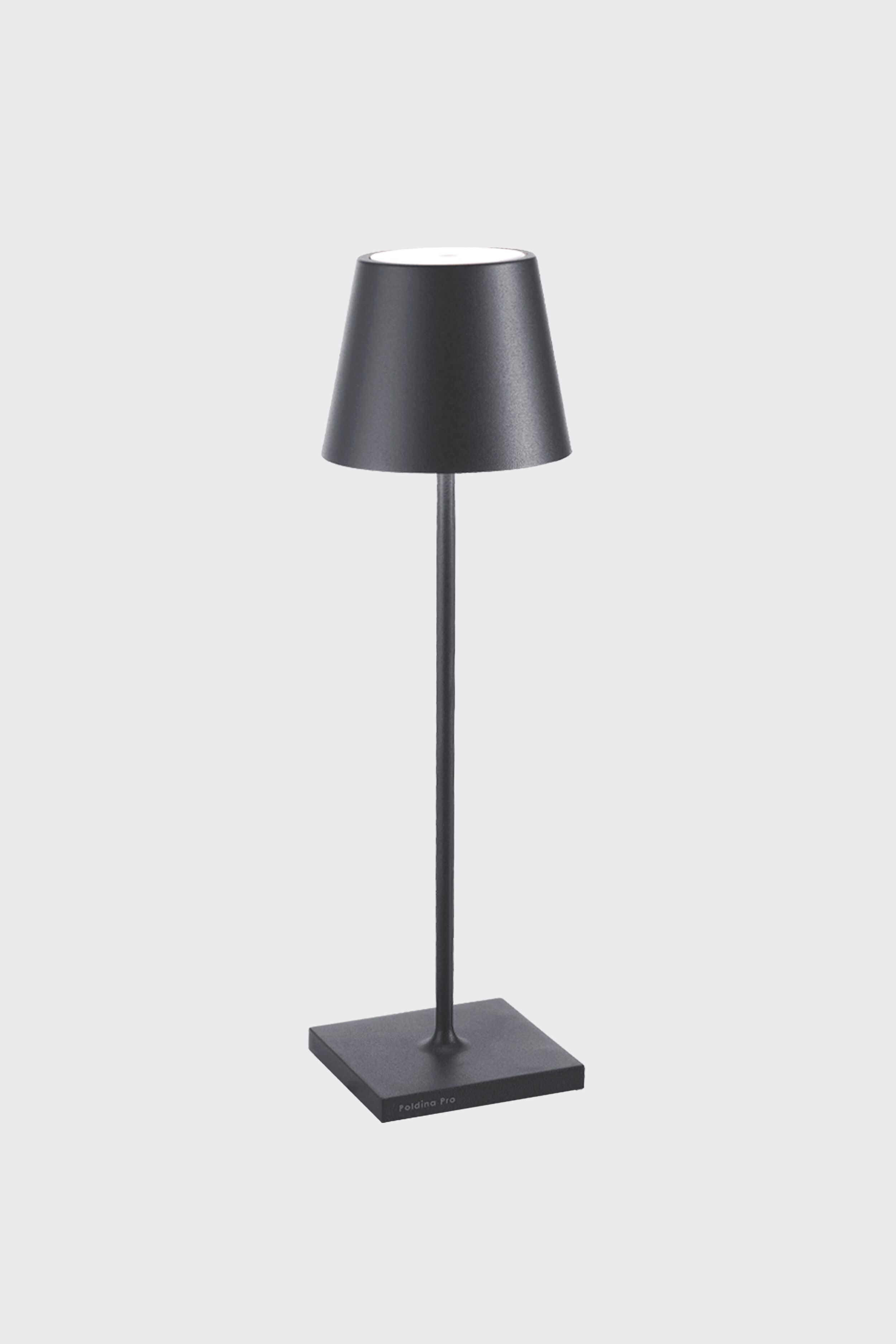 A black Zafferano Poldina Pro Table Lamp on a stand, featuring a rechargeable battery for cordless LED lighting convenience.