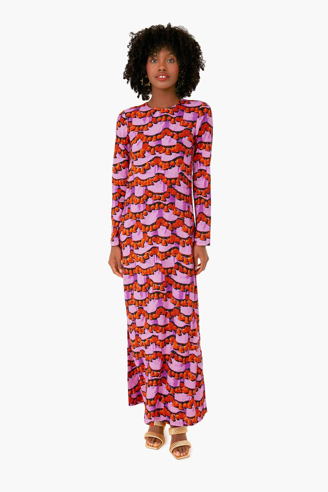A woman wears the La DoubleJ Liberace Ciclamino Long Sleeve Swing Dress—an elegant Italian evening gown featuring a vibrant red, orange, and purple geometric pattern.