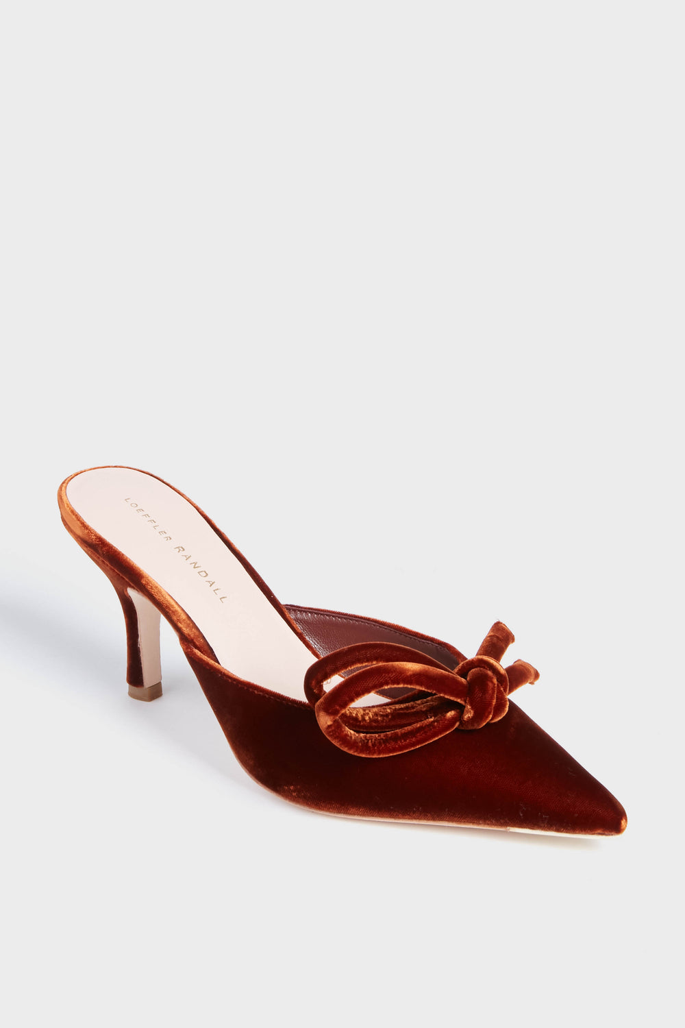 A rust-colored velvet mule from Loeffler Randall, featuring a bow detail, pointed toe, and mid-height stiletto heel from the Sienna Amyra Heels collection.