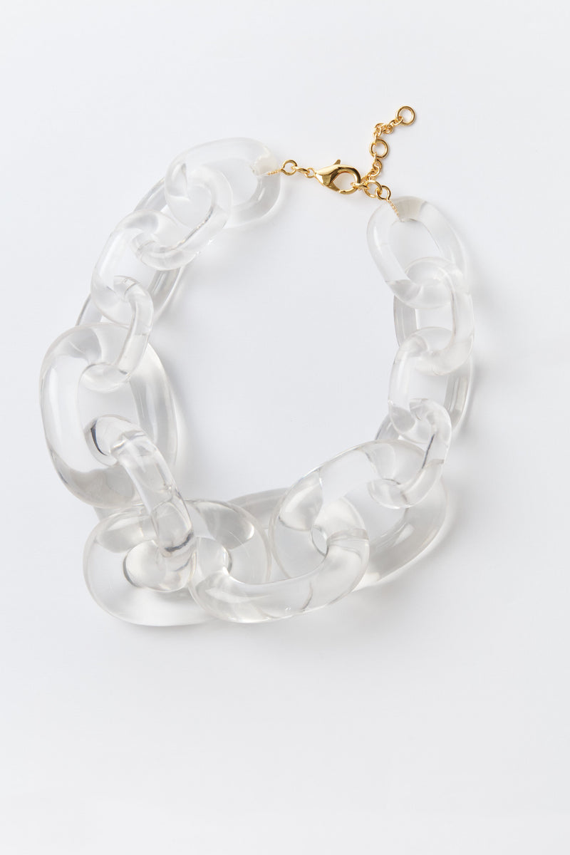 Chunky link necklace by Tuckernuck Jewelry featuring oversized clear acrylic links and a gold-tone clasp, stylishly coiled for display.
