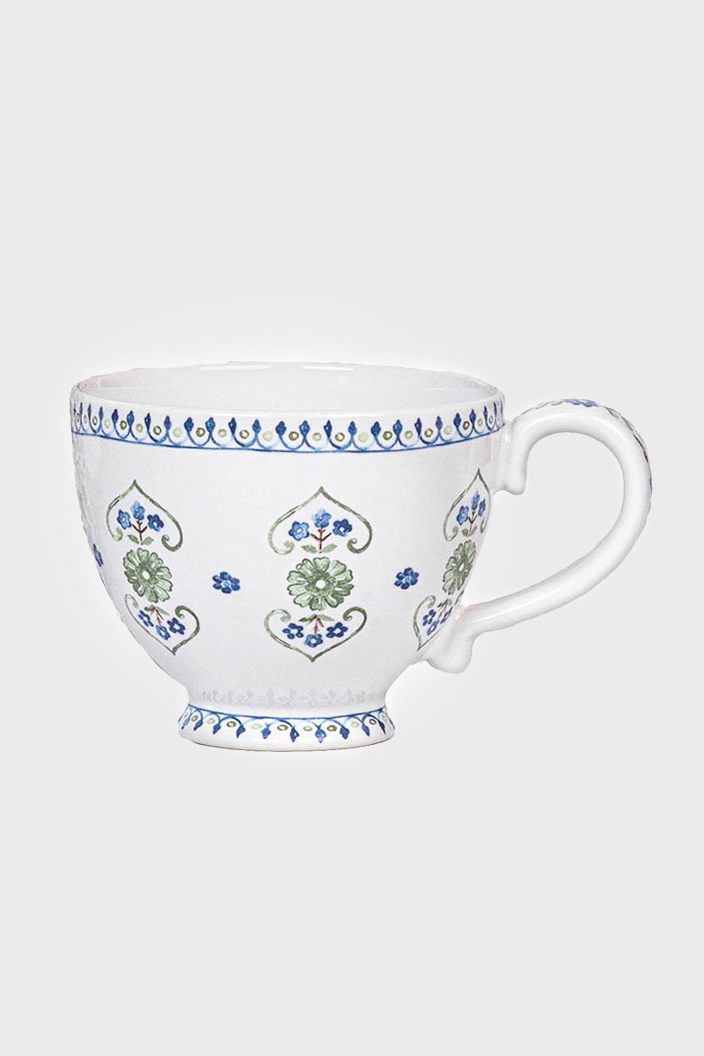 This Juliska white ceramic breakfast cup features a handle, blue and green floral patterns, and a blue rim border. Both practical and beautifully designed, it is dishwasher safe.