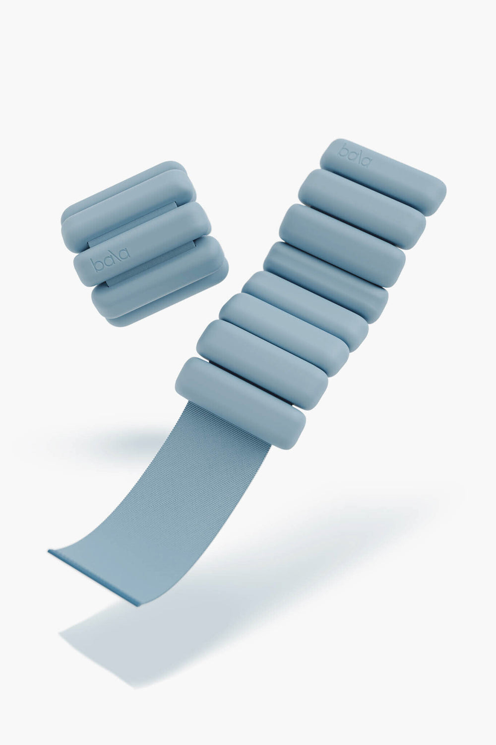 A pair of bala light blue wearable wrist weights—one coiled with visible fastener, the other straight—ideal for adding resistance to your workout.
