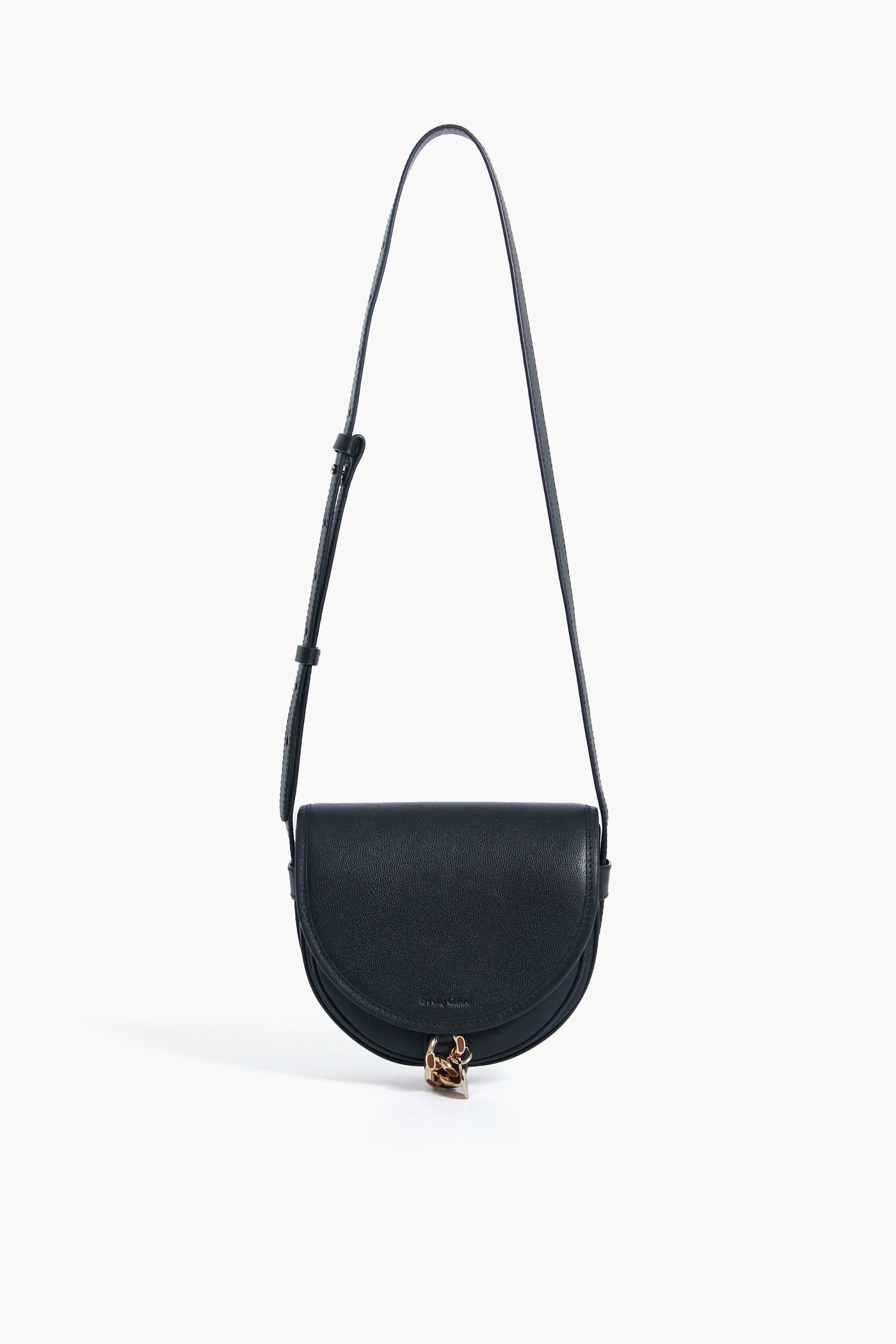A black See by Chloe crossbody bag made from cowhide, featuring a curved flap, adjustable strap, and gold clasp accent at the bottom center, inspired by the Mara Bag design.