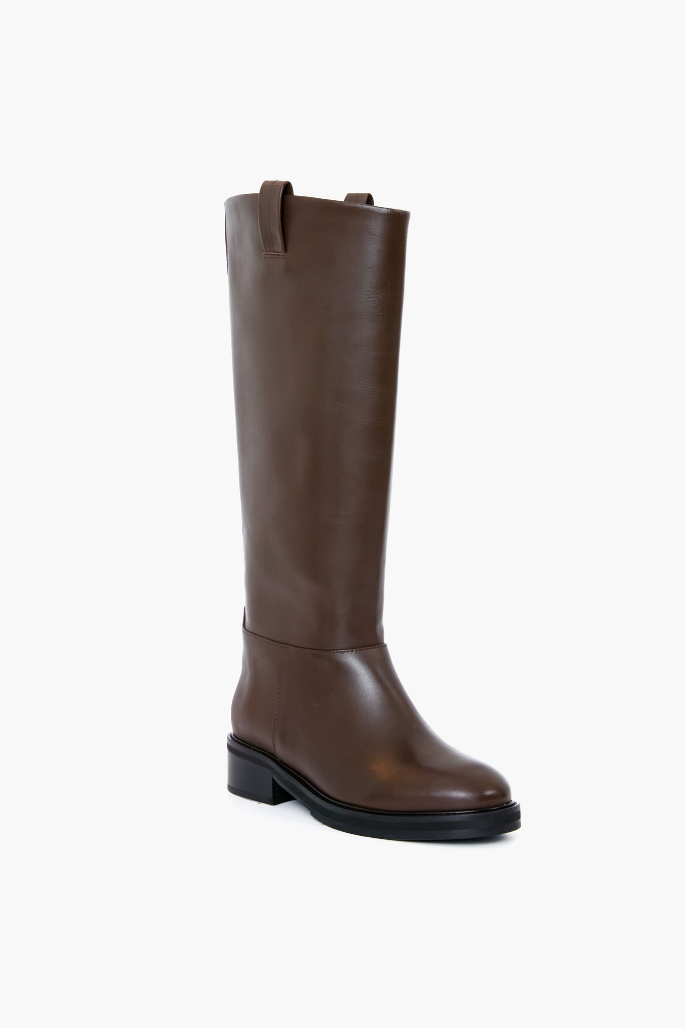 Flattered's handmade chocolate leather knee-high boot features a low heel and pull tabs, blending elegance and craftsmanship.
