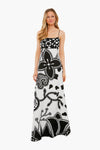 A woman wears an ALEXIS long, sleeveless dress in black and white womenswear, featuring bold floral and abstract patterns on printed twill.