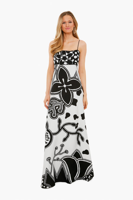 A woman wears an ALEXIS long, sleeveless dress in black and white womenswear, featuring bold floral and abstract patterns on printed twill.