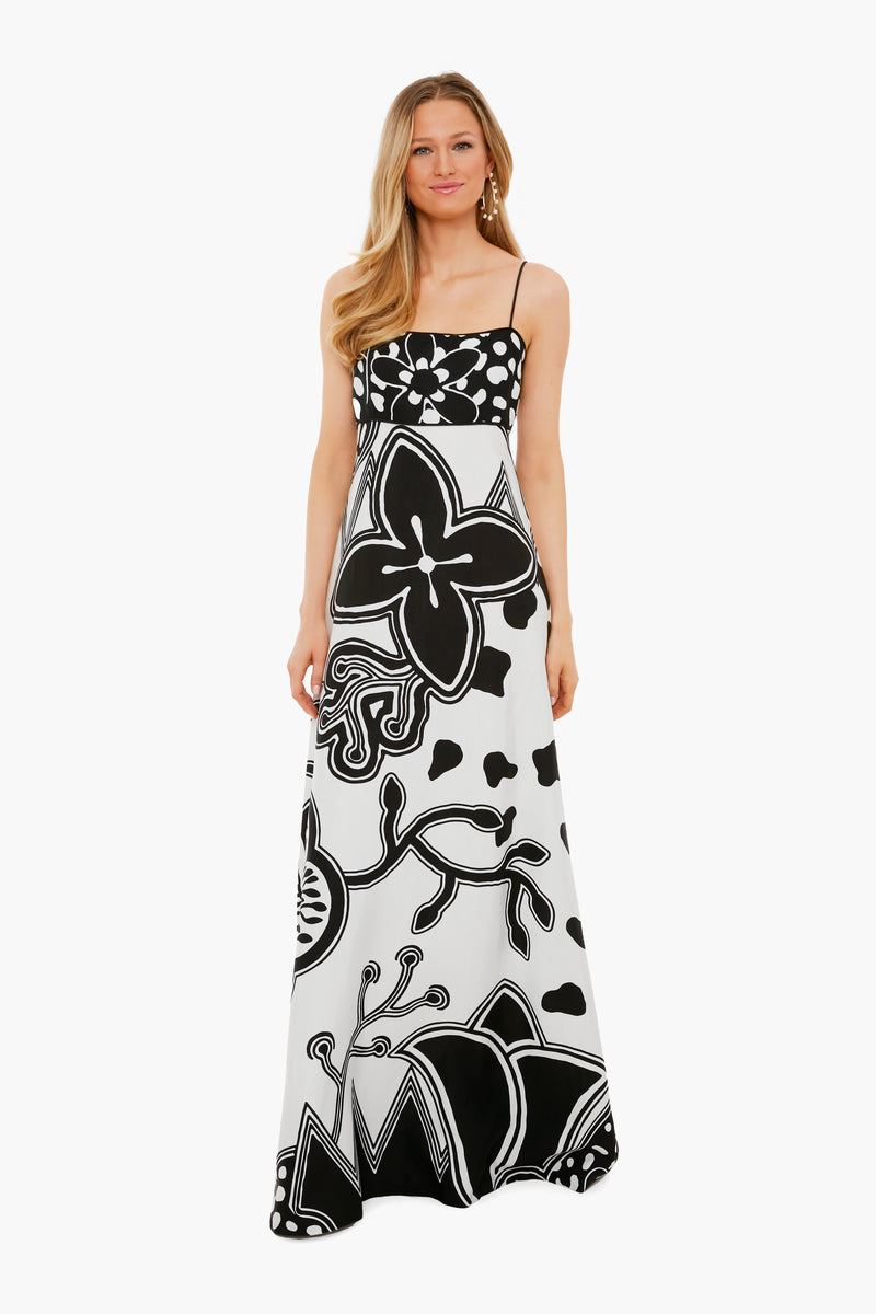 A woman wears an ALEXIS long, sleeveless dress in black and white womenswear, featuring bold floral and abstract patterns on printed twill.