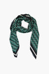 A green geometric print scarf by Tuckernuck Accessories, featuring a bold black and white zigzag pattern, angled ends, and a striking border—a standout style staple for any wardrobe.