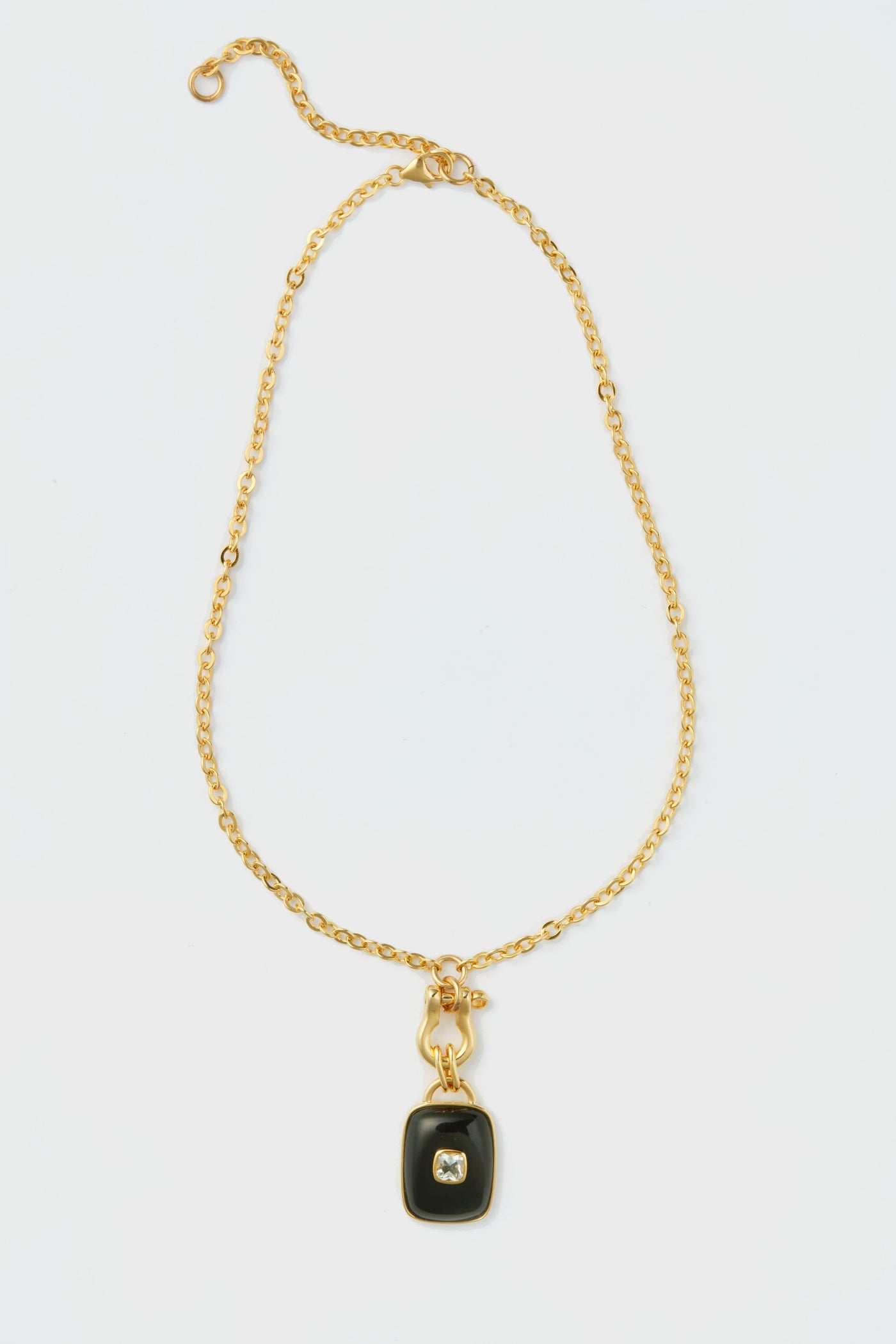 Lizzie Fortunato gold chain necklace with a rectangular black agate pendant and central clear gemstone, inspired by the Ancient City Necklace collection.