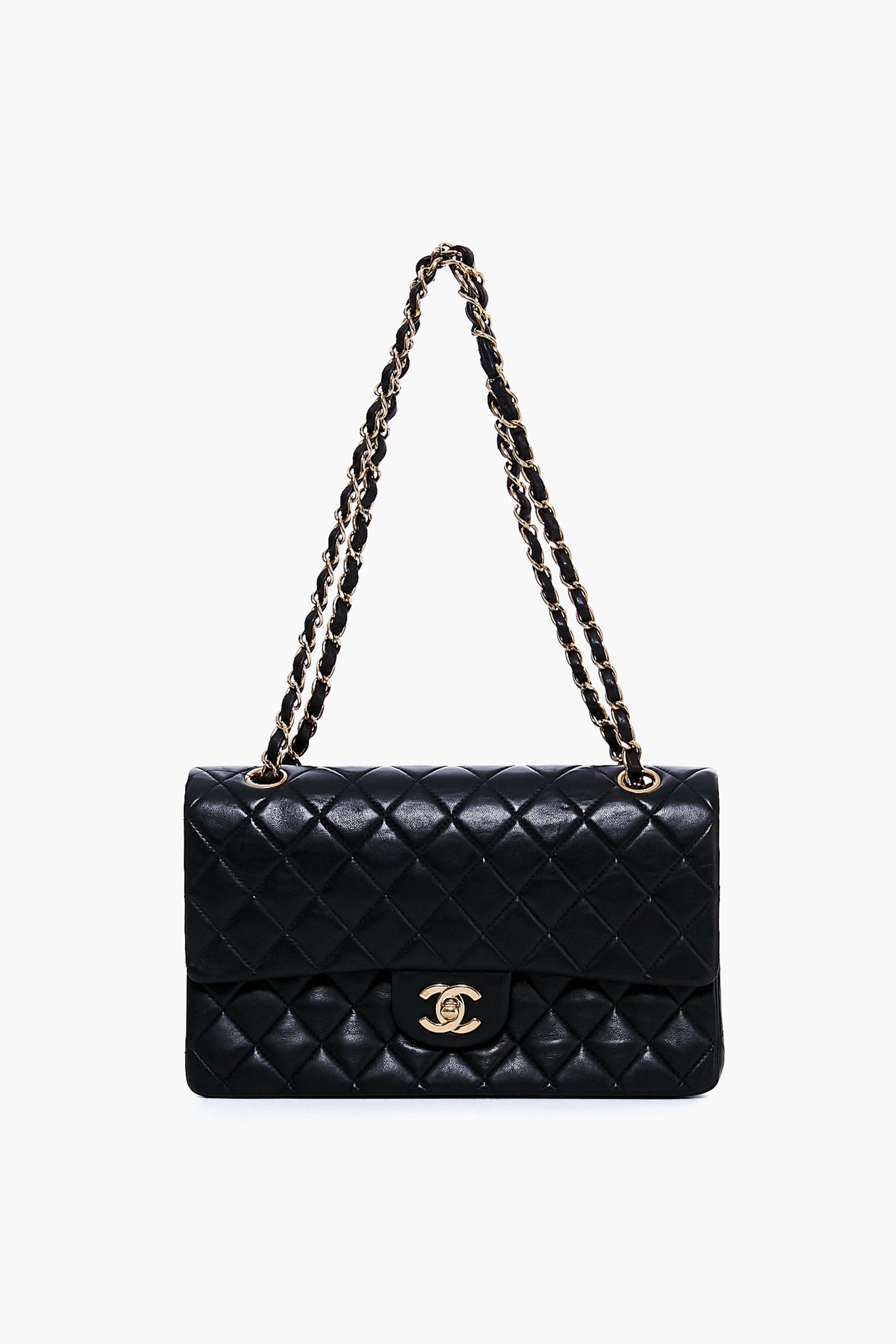 A black quilted leather Tuckernuck Archive Collection bag features a gold chain strap and a gold turn-lock clasp on the front flap.