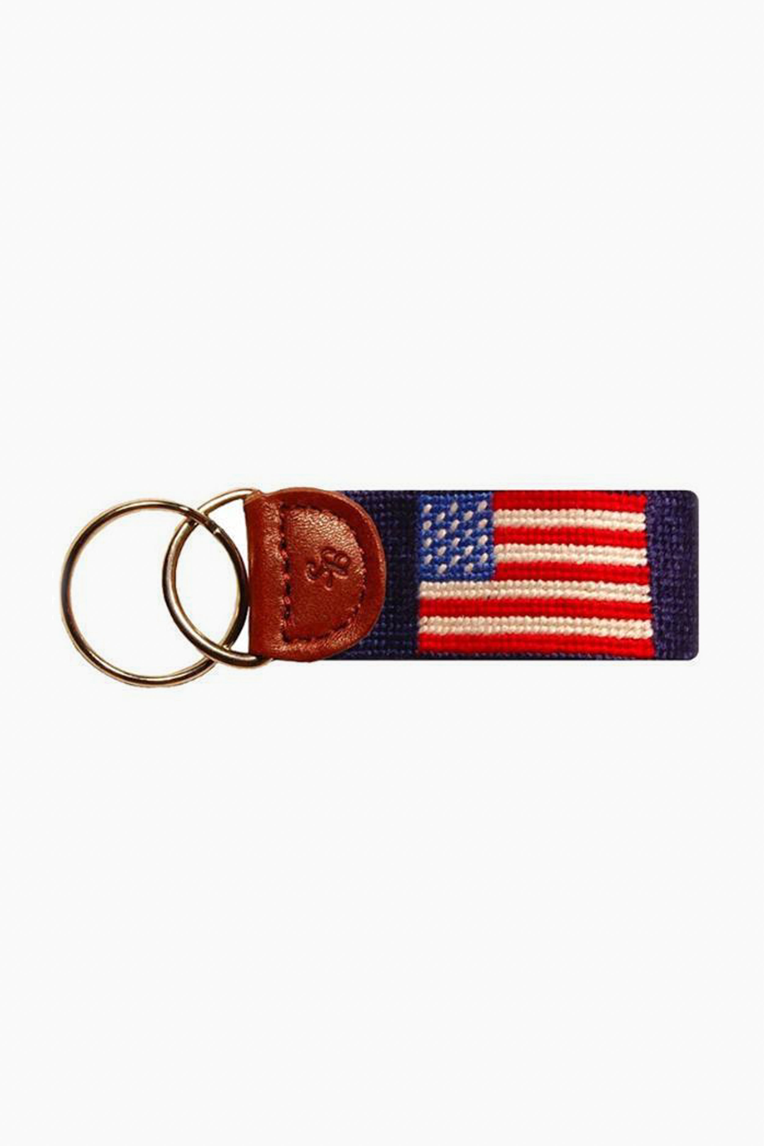 A Smathers and Branson keychain, hand-stitched with an American flag needlepoint design, features a leather accent and two metal key rings.