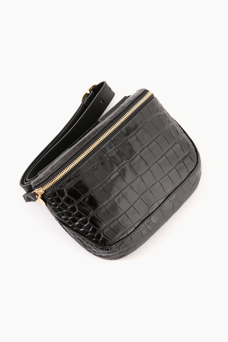 The Clare V black crocodile-printed leather crossbody bag features a gold zipper and adjustable strap, combining hands-free convenience with chic style.