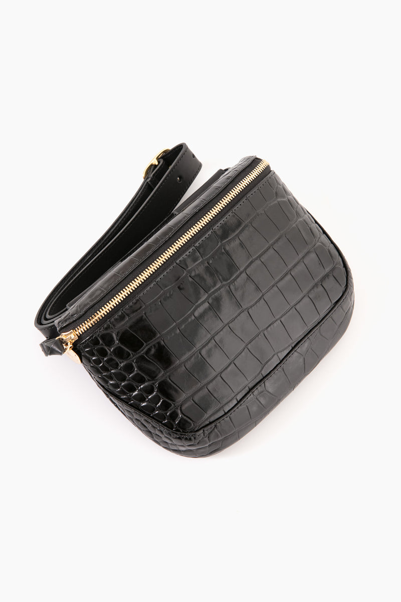 The Clare V black crocodile-printed leather crossbody bag features a gold zipper and adjustable strap, combining hands-free convenience with chic style.
