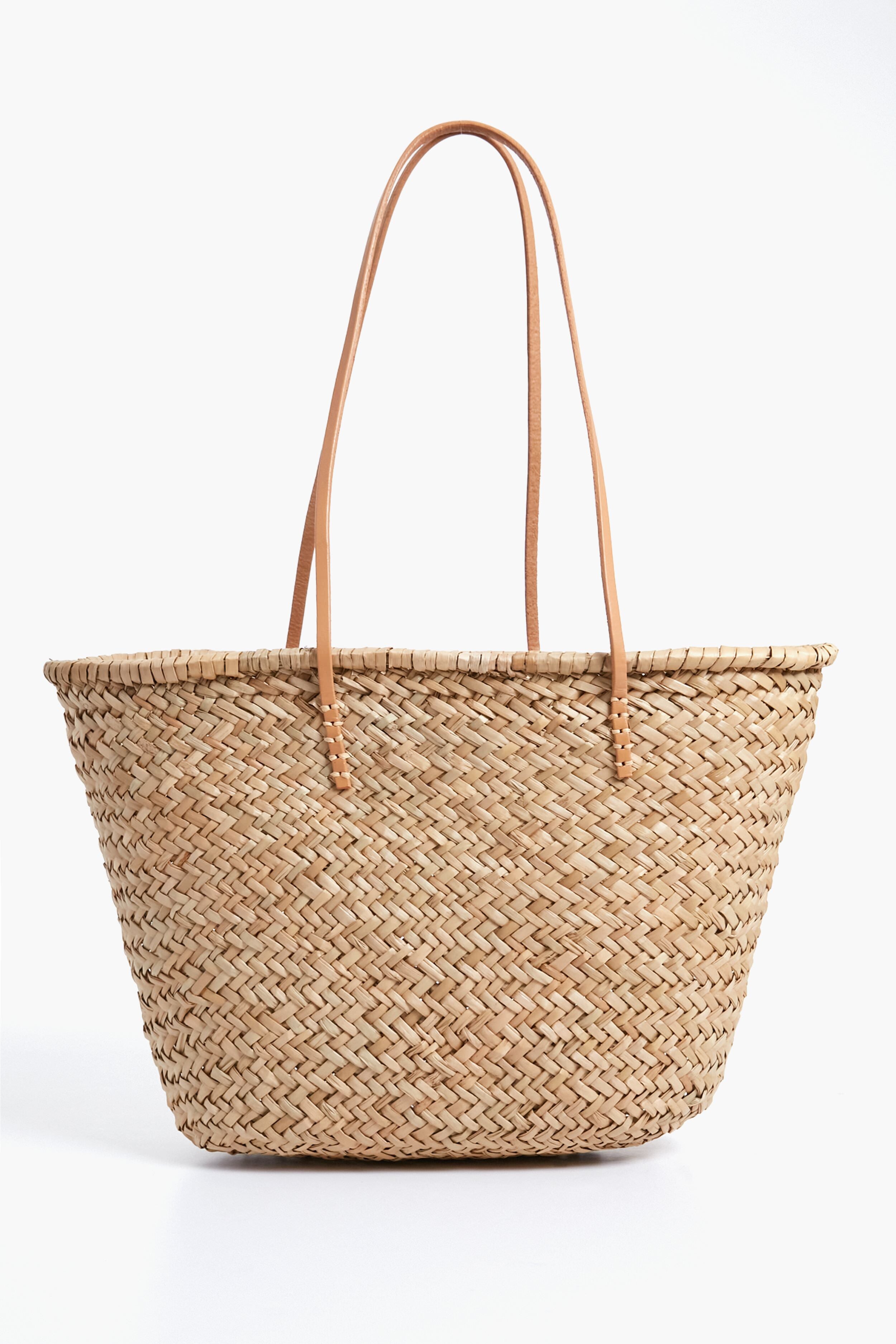 The Hat Attack Sorrento Tote is a woven straw bag with two long, thin leather handles—perfect for your next beach day.