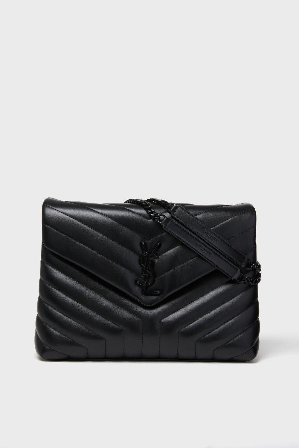 A black Tuckernuck Archive Collection bag featuring quilted chevron leather, a chain strap, and an embossed logo on the front.