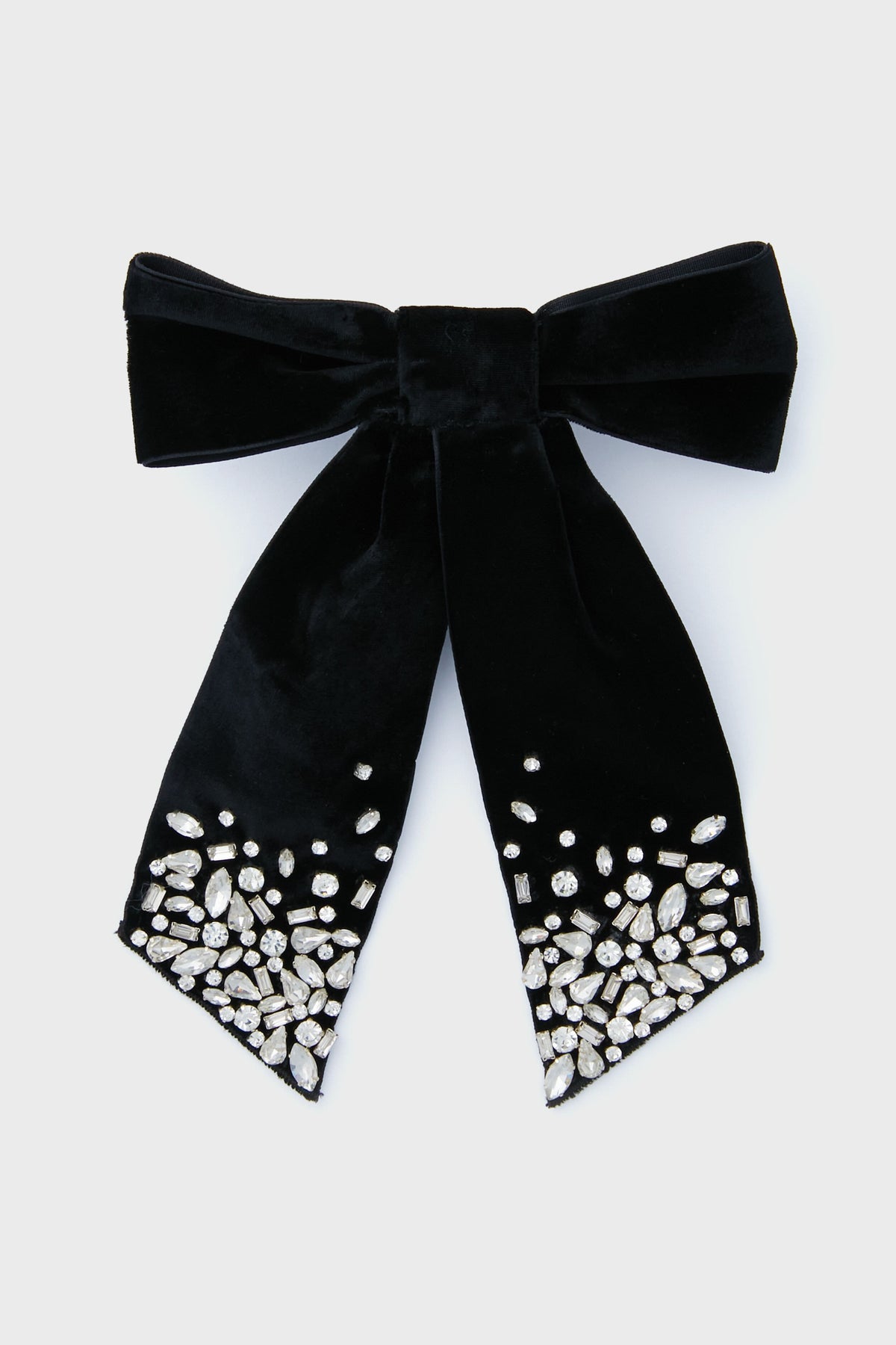 The Mignonne Gavigan black velvet hair bow features two ribbon tails with clusters of clear rhinestones at the ends—an elegant accessory to add sparkle and style to your look.