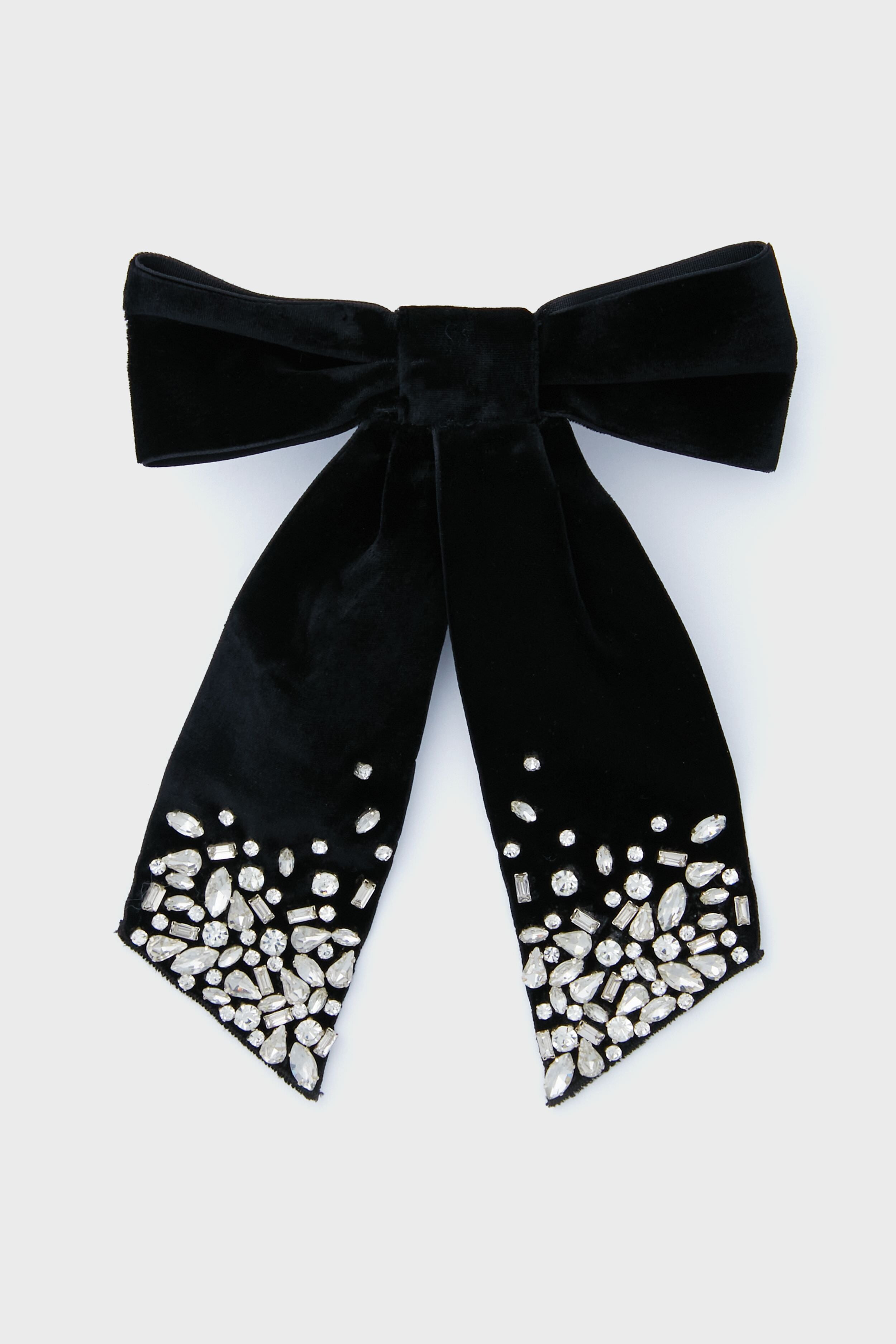 The Mignonne Gavigan black velvet hair bow features two ribbon tails with clusters of clear rhinestones at the ends—an elegant accessory to add sparkle and style to your look.