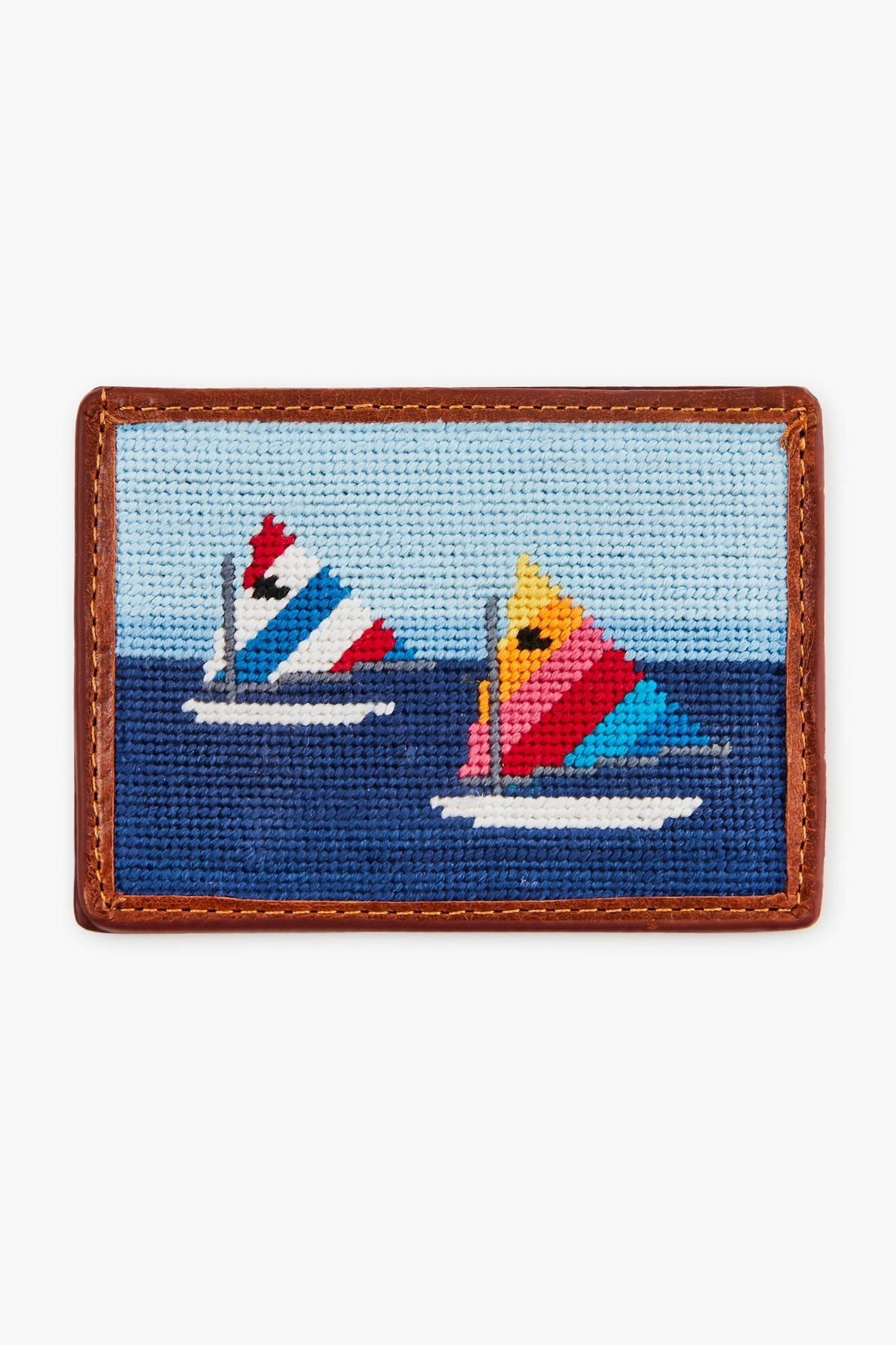 Smathers and Branson’s rectangular hand-stitched needlepoint card wallet features two colorful sailboats on blue water and is trimmed with brown Italian leather.