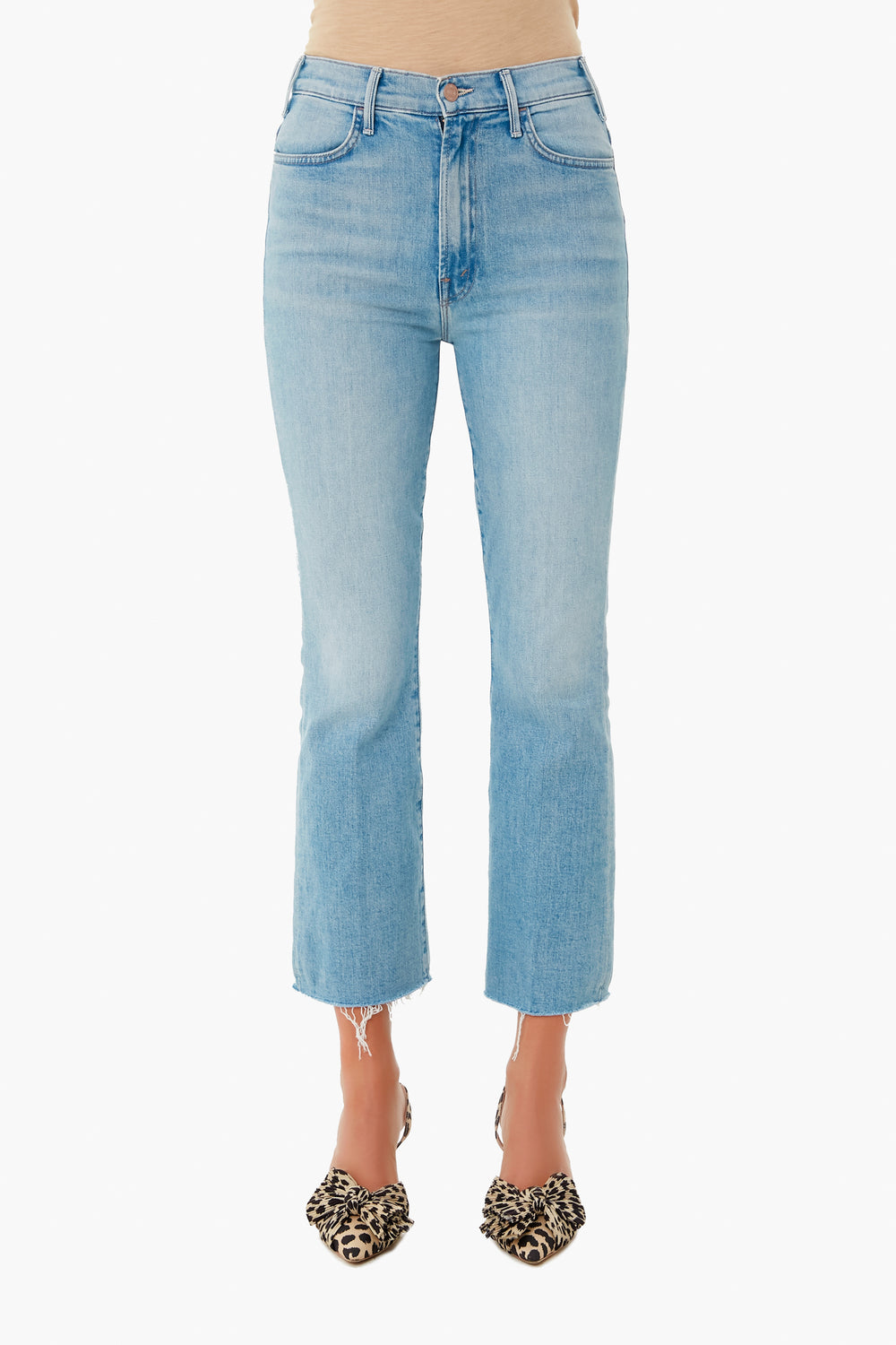A person wears MOTHER light wash high-waisted cropped ankle jeans with a raw hem and animal print pointed-toe flats.
