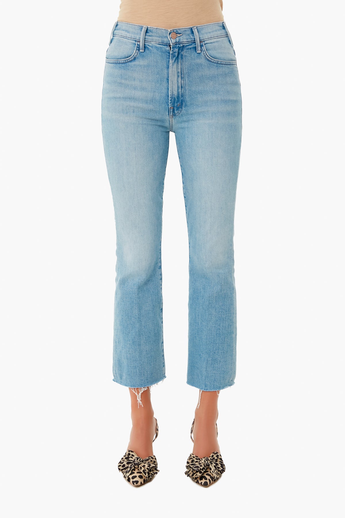 A person wears MOTHER light wash high-waisted cropped ankle jeans with a raw hem and animal print pointed-toe flats.