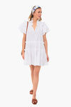 A woman wears the Hunter Bell Merritt Dress, a white cotton poplin ruffled mini dress.