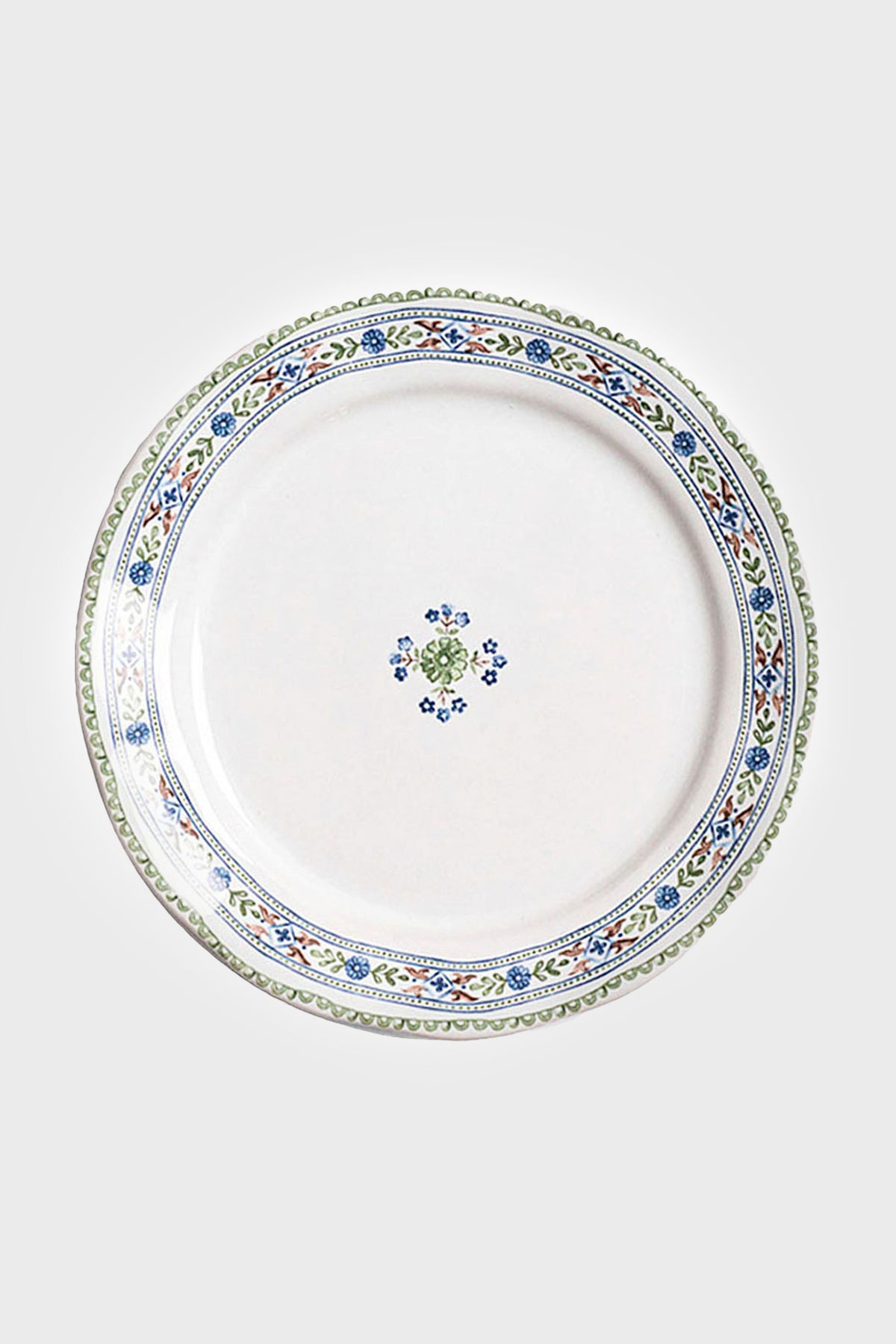 White ceramic salad plate from Juliska featuring a blue, green, and yellow floral rim and a small center motif. Dishwasher safe.