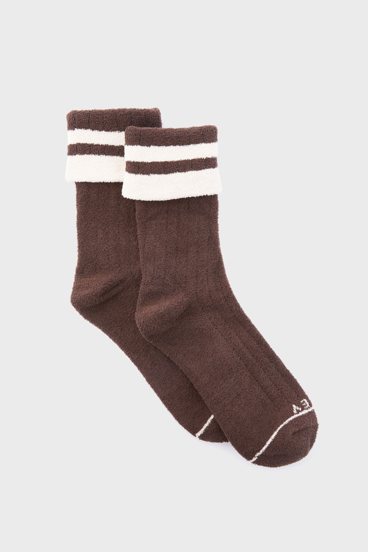 A pair of brown Varley Preston Sock boucle crew socks with white stripes near the top and a small white logo on the toe, perfect as women’s cozy socks.