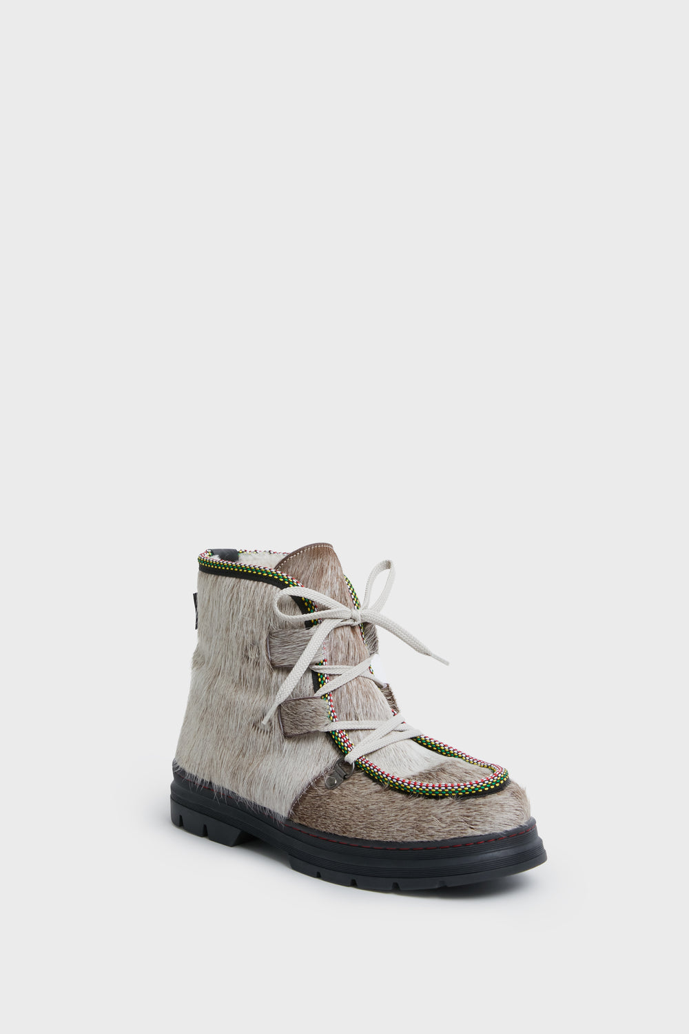 A Penelope Chilvers lace-up boot featuring a fur-textured upper, multicolored trim, white laces, and a black rubber sole—designed for cozy comfort and inspired by classic Penelope Chilvers pony boots.