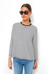 Woman wearing Pomander Place black sunglasses, gold jewelry, a white and navy striped relaxed-fit long sleeve tee in soft cotton blend, and blue jeans.