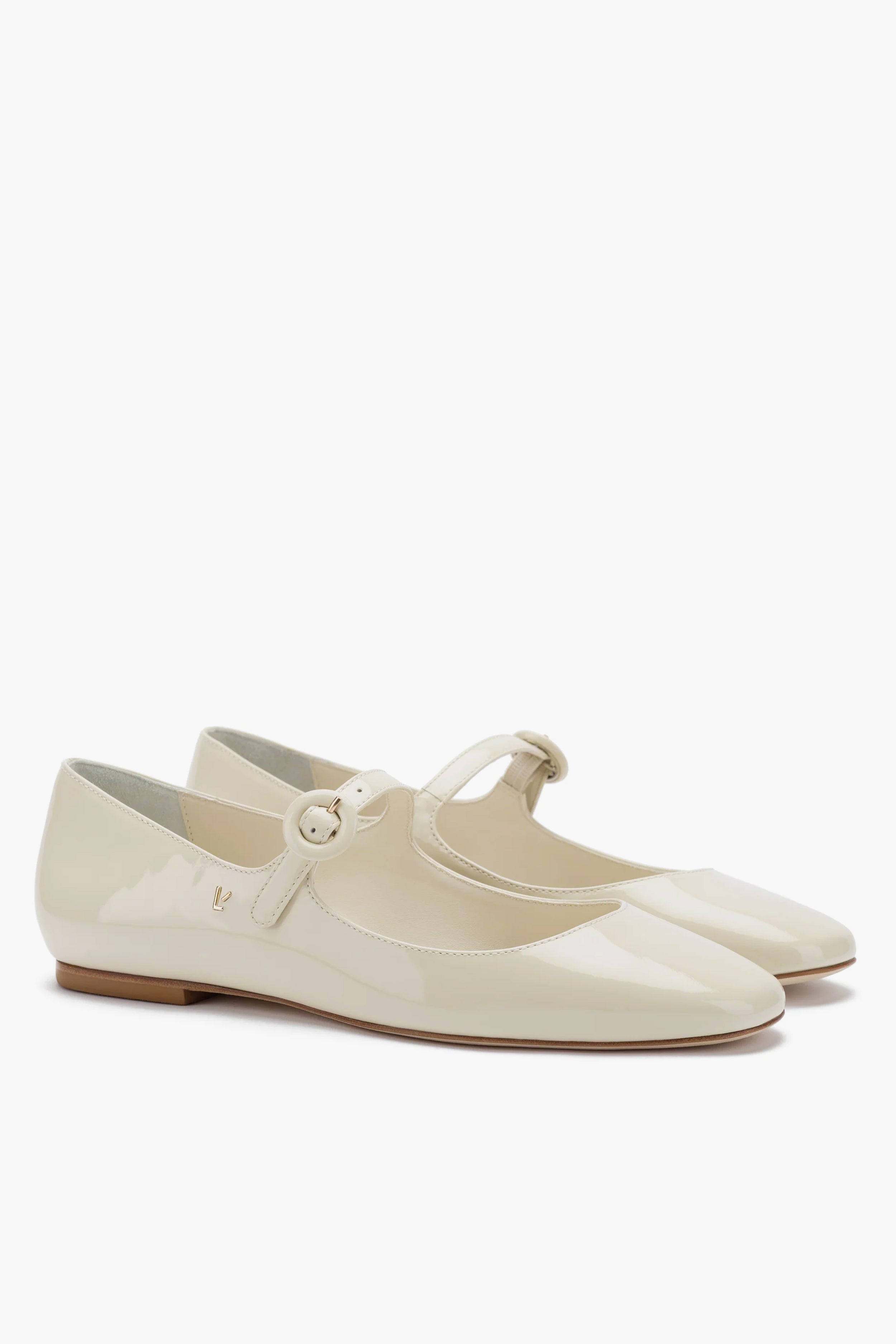 A pair of Larroude glossy beige Ivory Blair Ballet Flats in classic mary jane style, featuring a rounded toe, low heel, thin strap with round buckle, and memory foam cushioned insole for comfort.