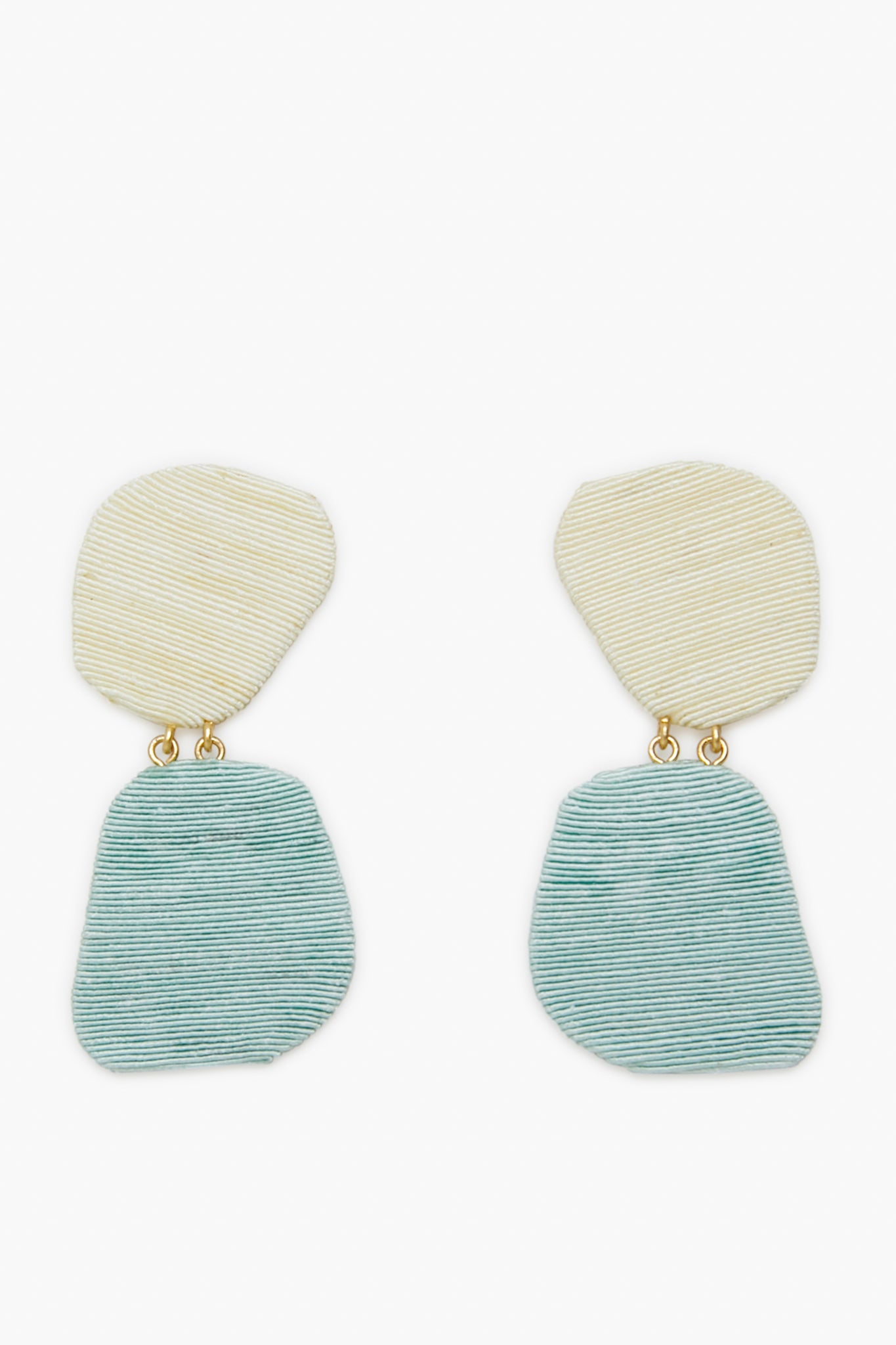 Tuckernuck Jewelry’s Ula Earrings feature irregular, textured ovals—off-white on top, light blue below—joined by small gold links. Lightweight and hypoallergenic, they provide comfort and a modern look.