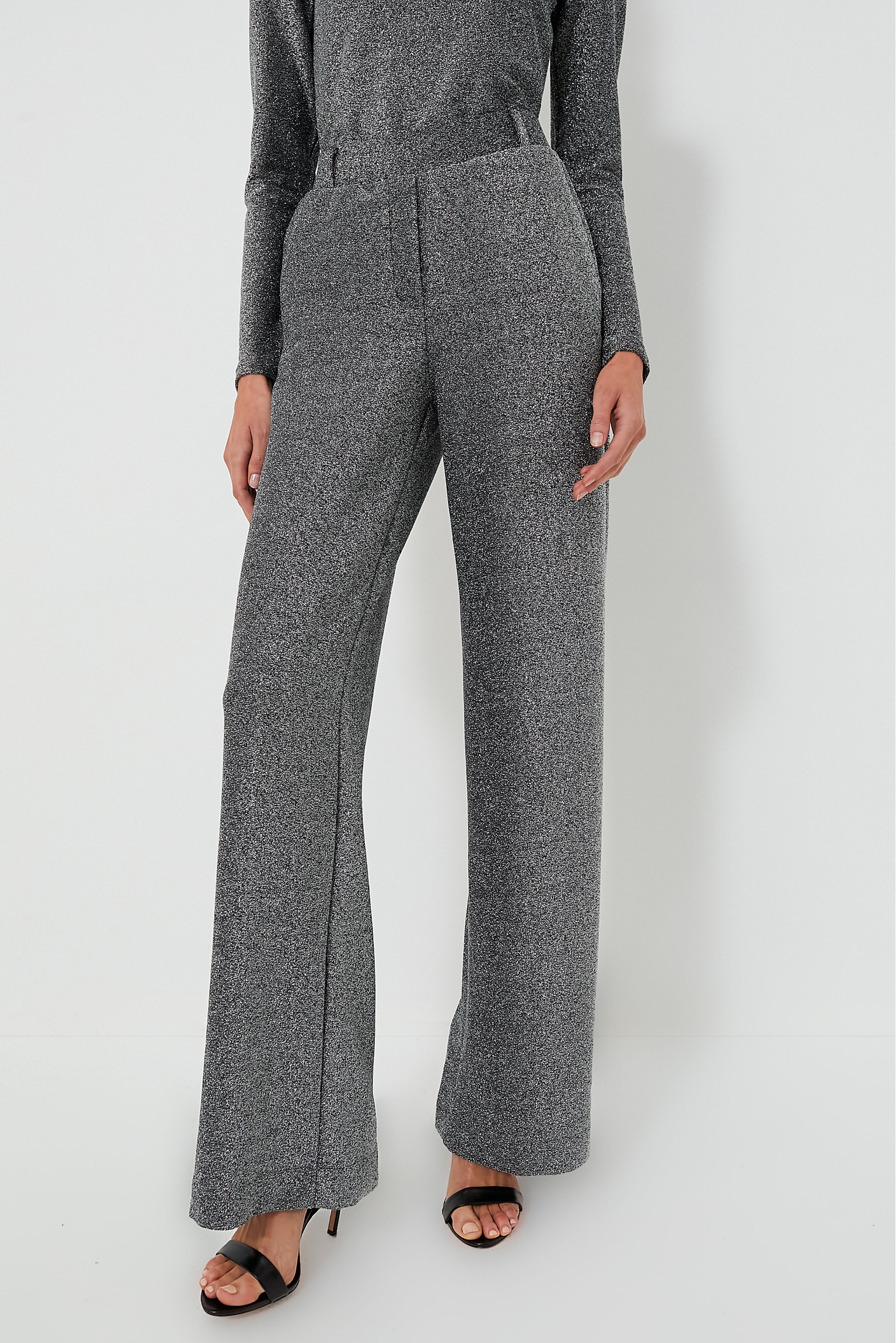 Person wearing high-waisted, wide-leg Jya Pant in Shimmer Gray from Baum Und Pferdgarten with black heeled sandals, standing confidently.