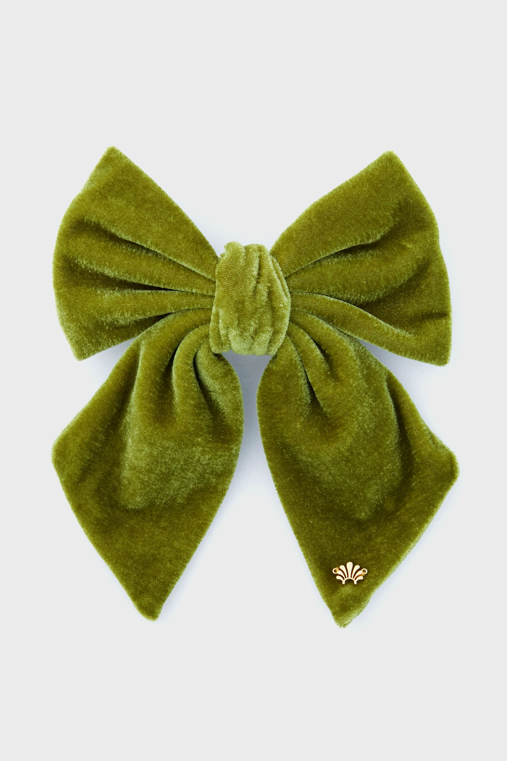 The Lele Sadoughi large green velvet bow features wide loops, flowing tails, and a small gold decorative emblem—an eye-catching statement accessory for hair enthusiasts.