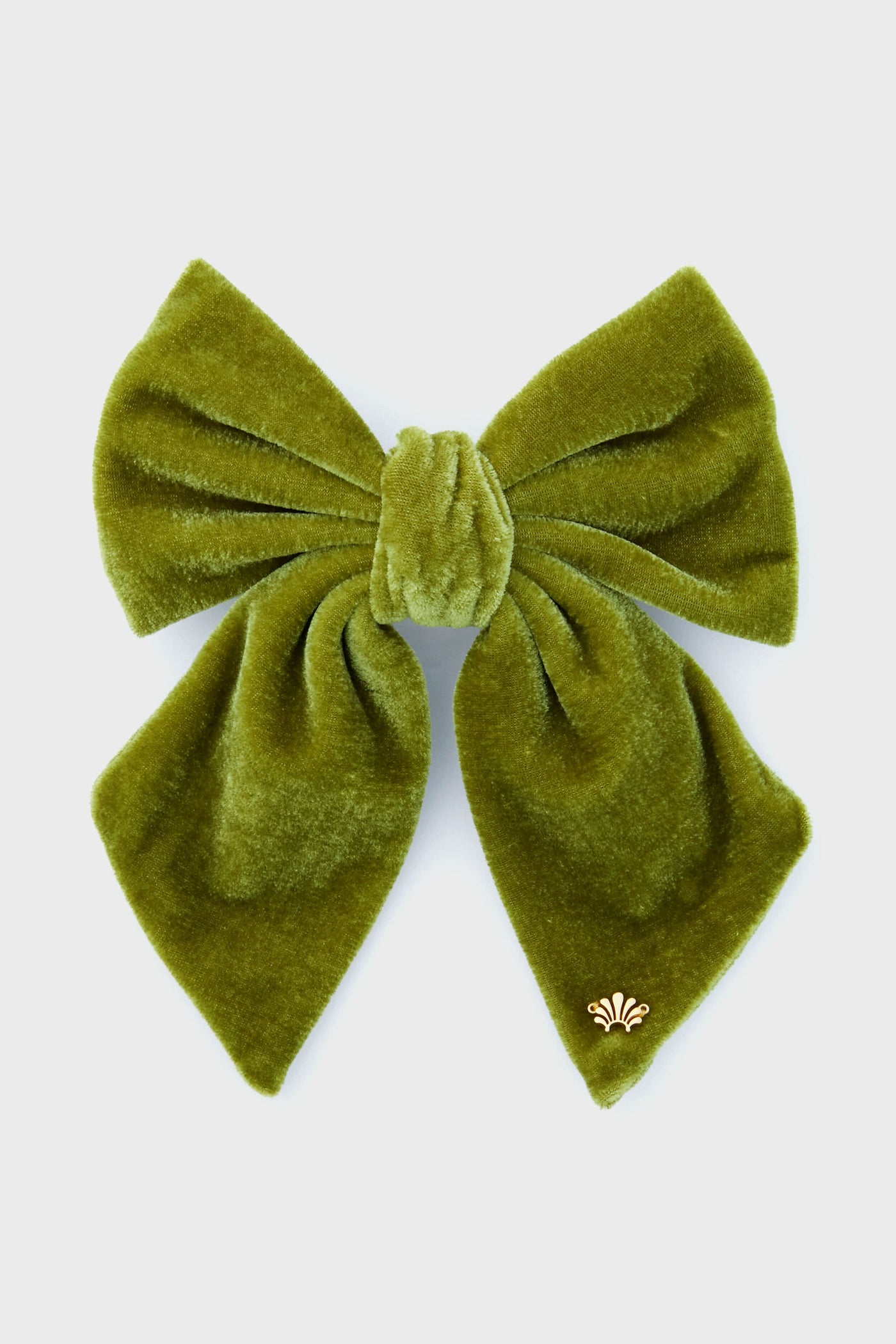 The Lele Sadoughi large green velvet bow features wide loops, flowing tails, and a small gold decorative emblem—an eye-catching statement accessory for hair enthusiasts.