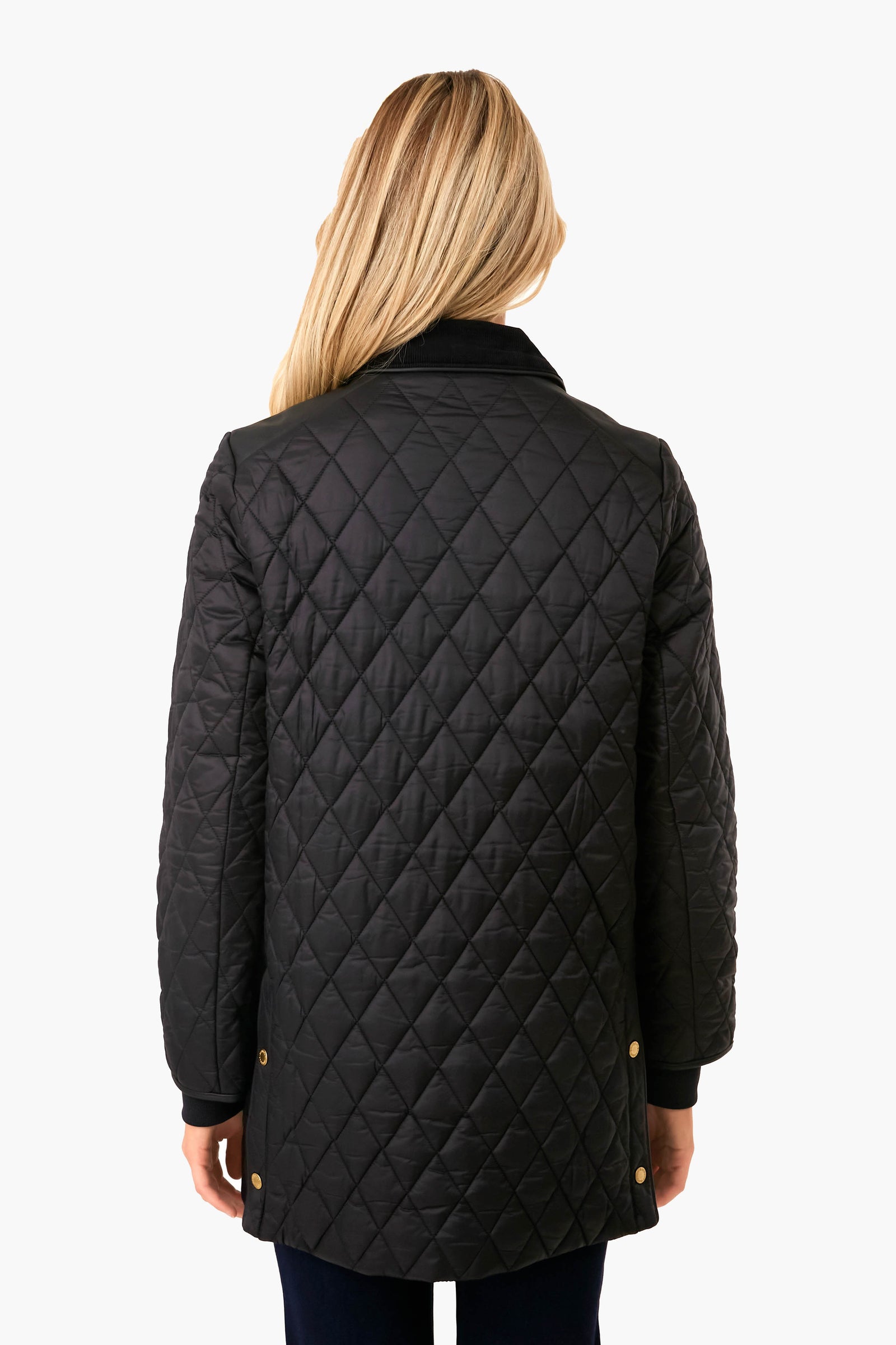 Back view of a woman wearing the classic Black Kilmarie Quilt coat, featuring diamond quilting, snap-button details, and a cord collar, embodying effortless, high-end style.