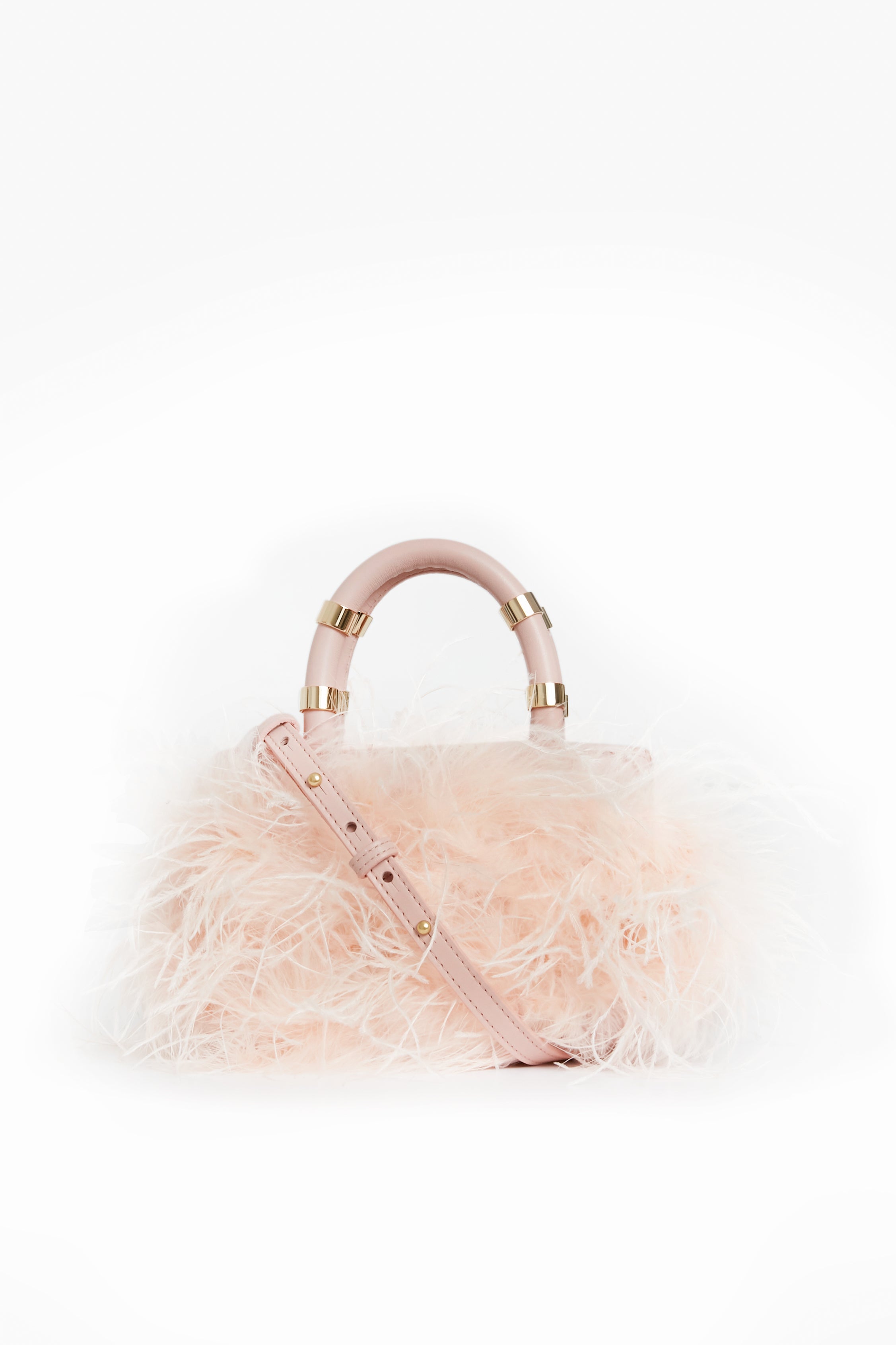 The J.LOWERY bag features a light pink ostrich feather design, gold hardware, a top handle, detachable shoulder strap, and soft feather-like detailing.