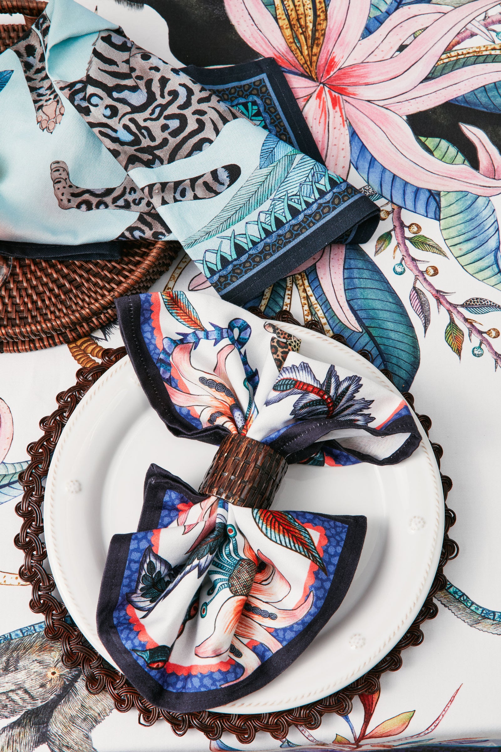 Tabletop display featuring the Tanzanite Cheetah Kings Tea Towel with regal cheetahs, blending classic style and effortless fun amidst high-end, vibrant table settings.