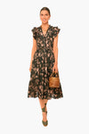 A woman in a Ulla Johnson floral shadow stripe cotton midi dress with ruffled sleeves, green ankle-tie shoes, and a round woven handbag.