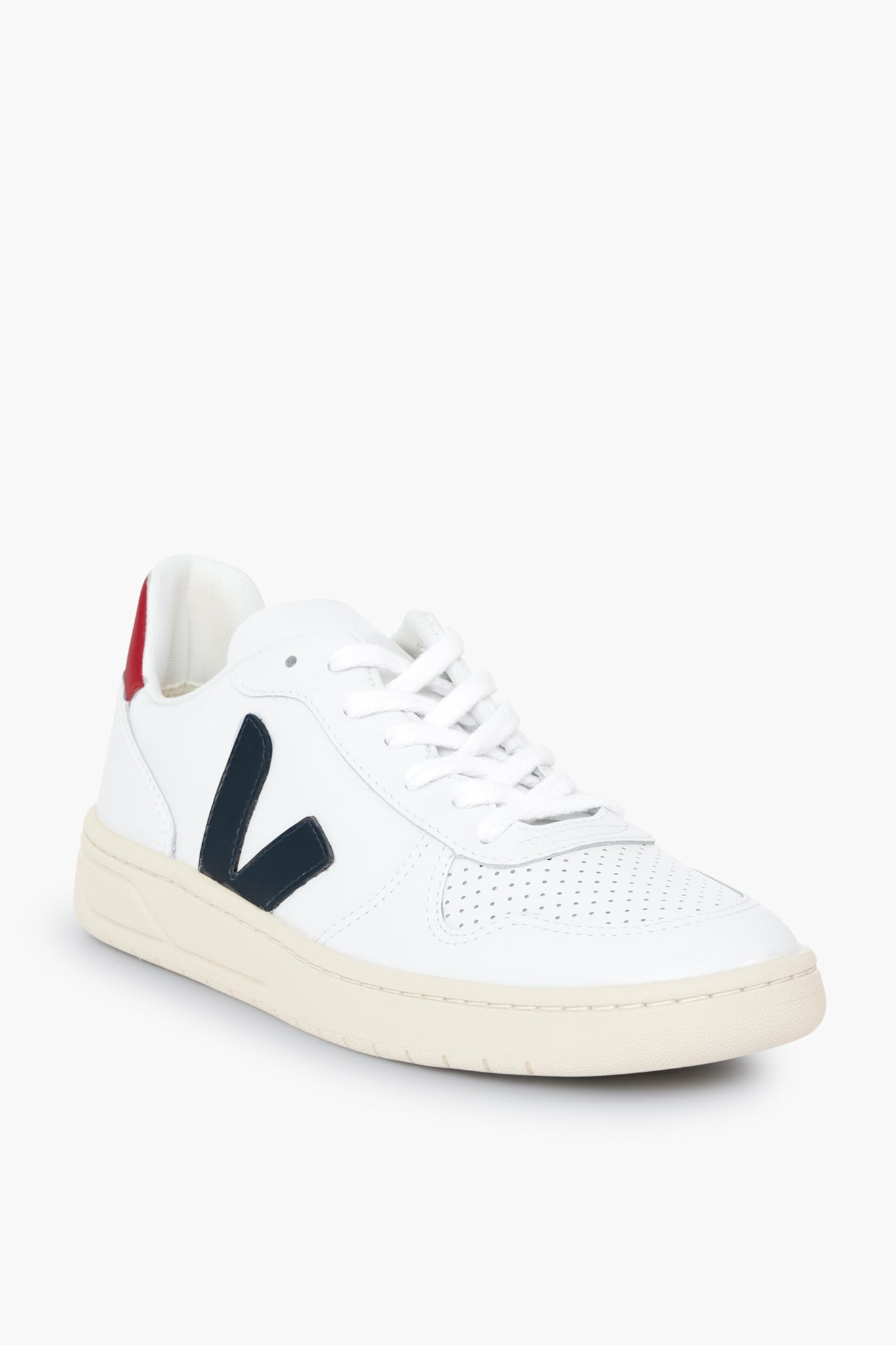 A sustainable white low-top VEJA sneaker featuring a perforated toe, black side V logo, white laces, beige sole, and a red heel accent—crafted from organic cotton.