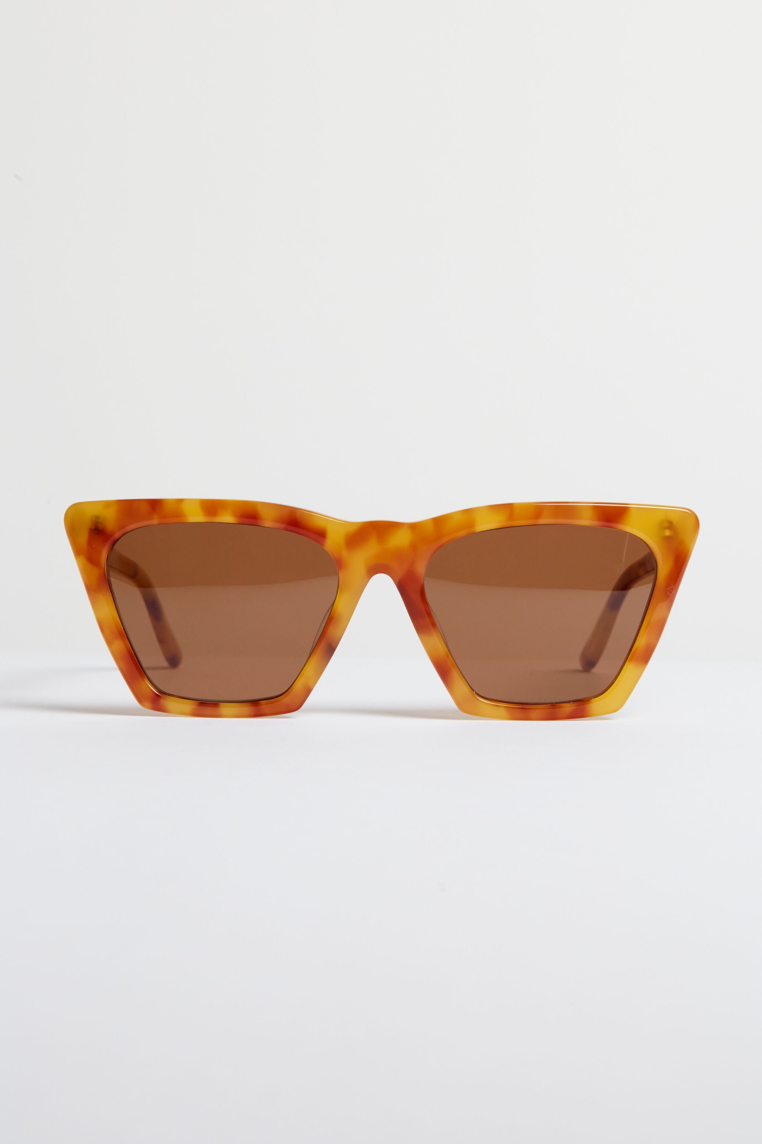 A pair of angular tortoise-frame sunglasses with brown lenses—the Amber Lisbon Sunglasses by Illesteva showcase handmade Italian craftsmanship.