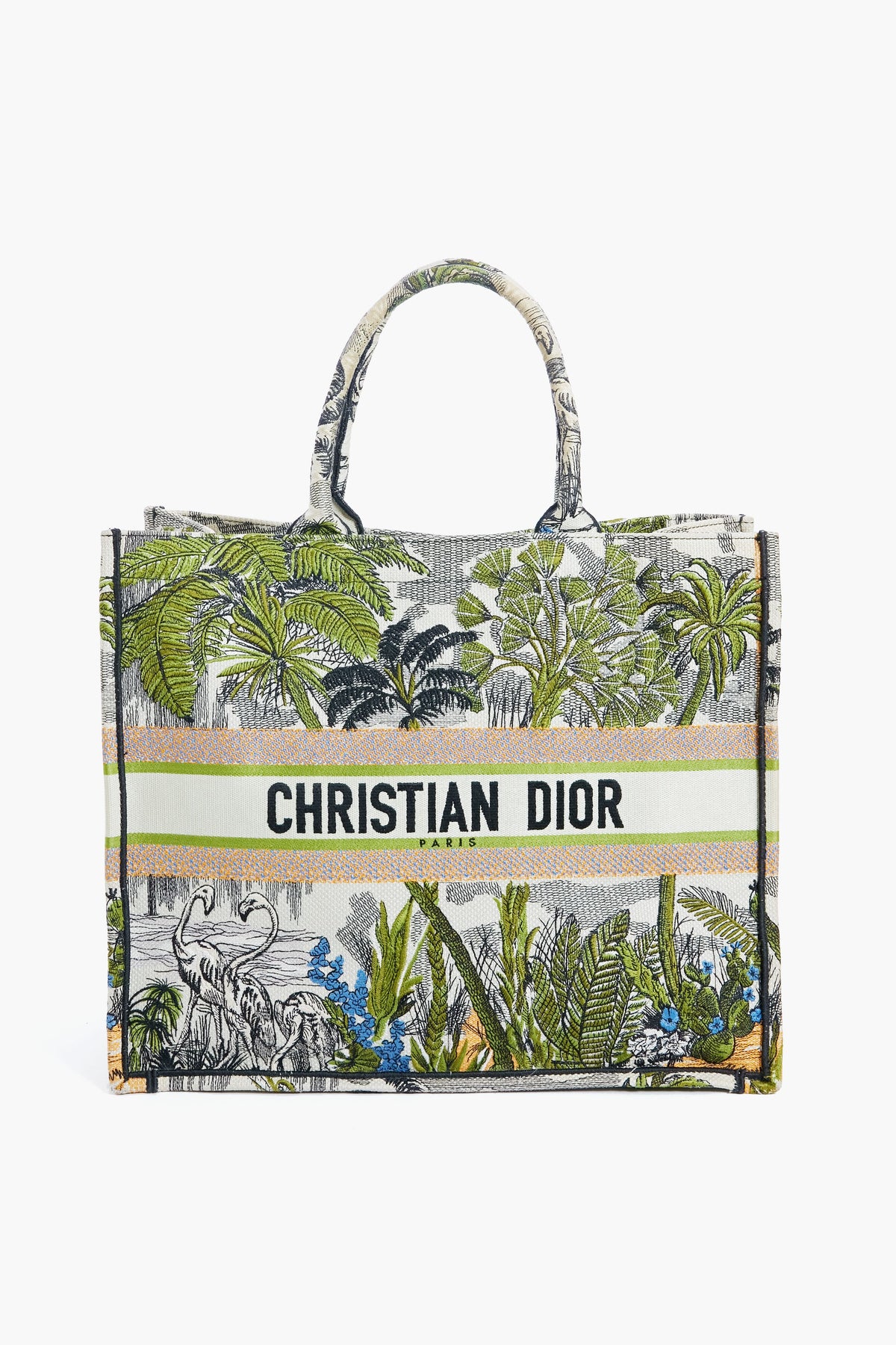 A Tuckernuck Archive Collection Book Tote featuring green tropical foliage, flowers, and animals, with the brand name Tuckernuck Archive Collection printed across the front.