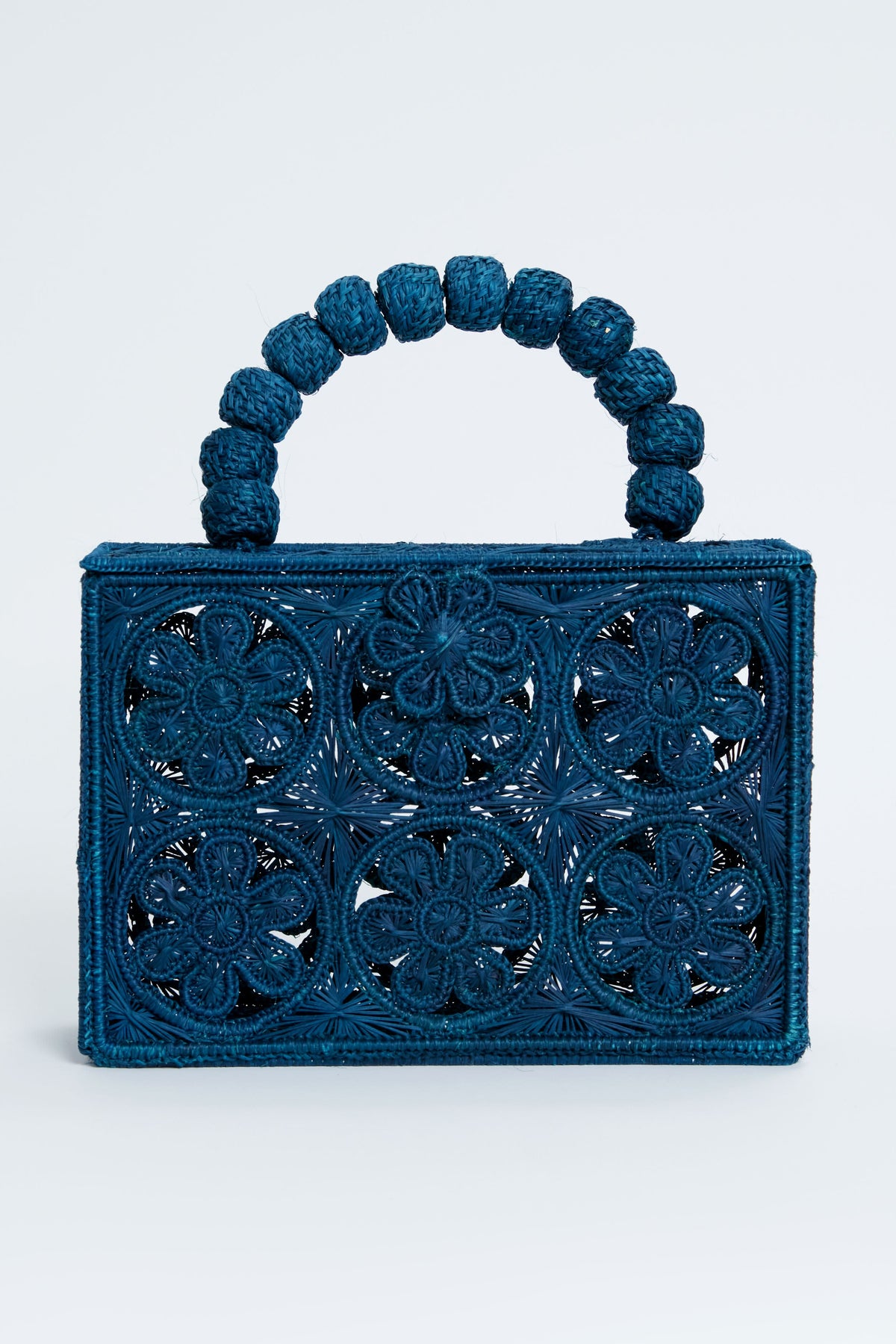 ASHA x Tuckernuck rectangular blue floral clutch with intricate cutout pattern and a handle of large woven beads—perfect for the beach.