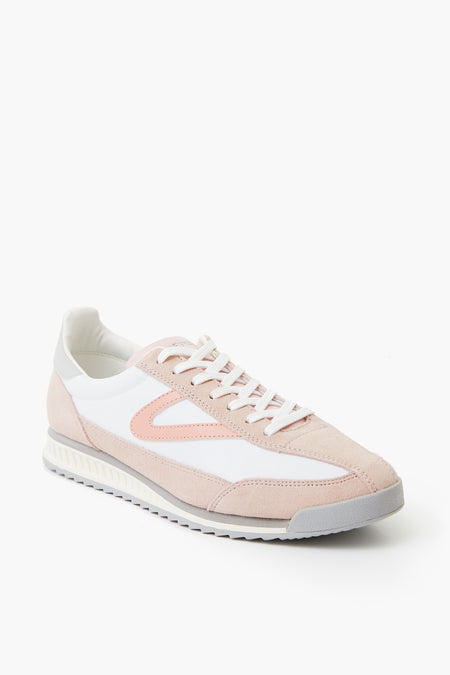 The Tretorn Retro Rawlins Sneaker features light pink and white colors, a grey sole, white laces, and a low-top design—ideal for casual wear.