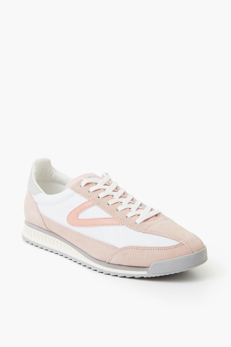 The Tretorn Retro Rawlins Sneaker features light pink and white colors, a grey sole, white laces, and a low-top design—ideal for casual wear.