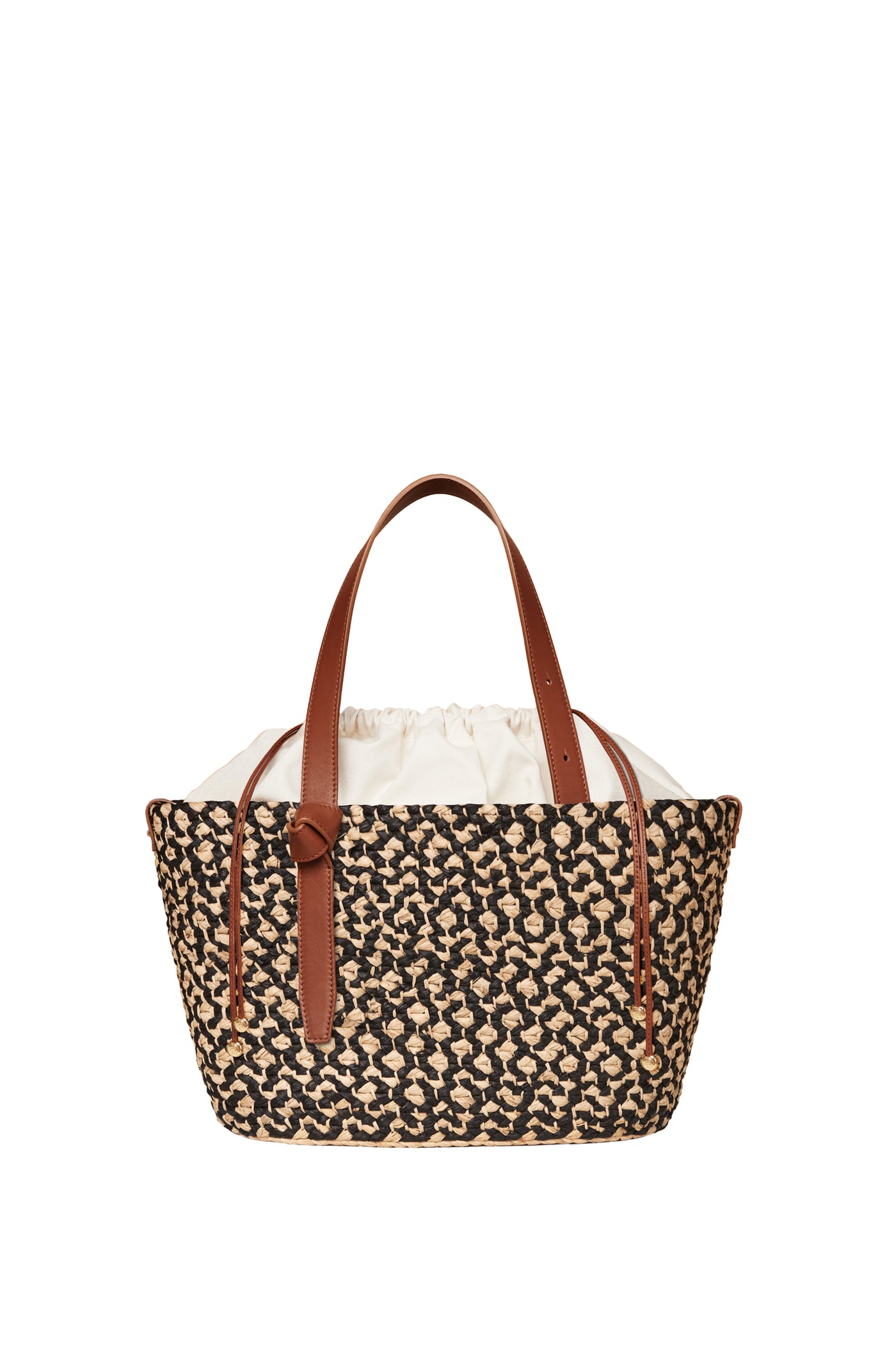 Cesta Collective handwoven raffia tote bag featuring a black and natural pattern, brown leather handles, and a white fabric drawstring lining.